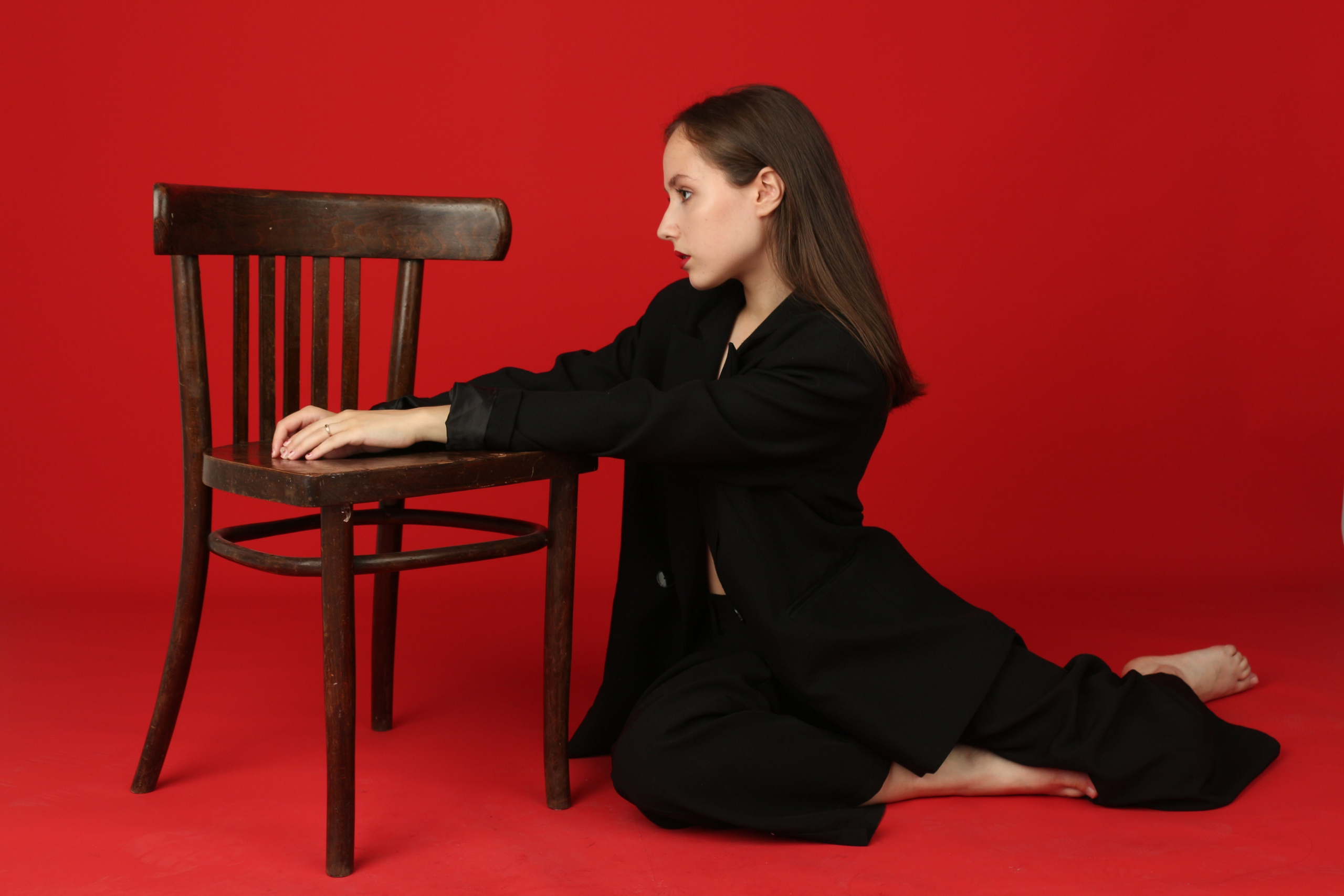 Девушка в черном костюме на красном фоне