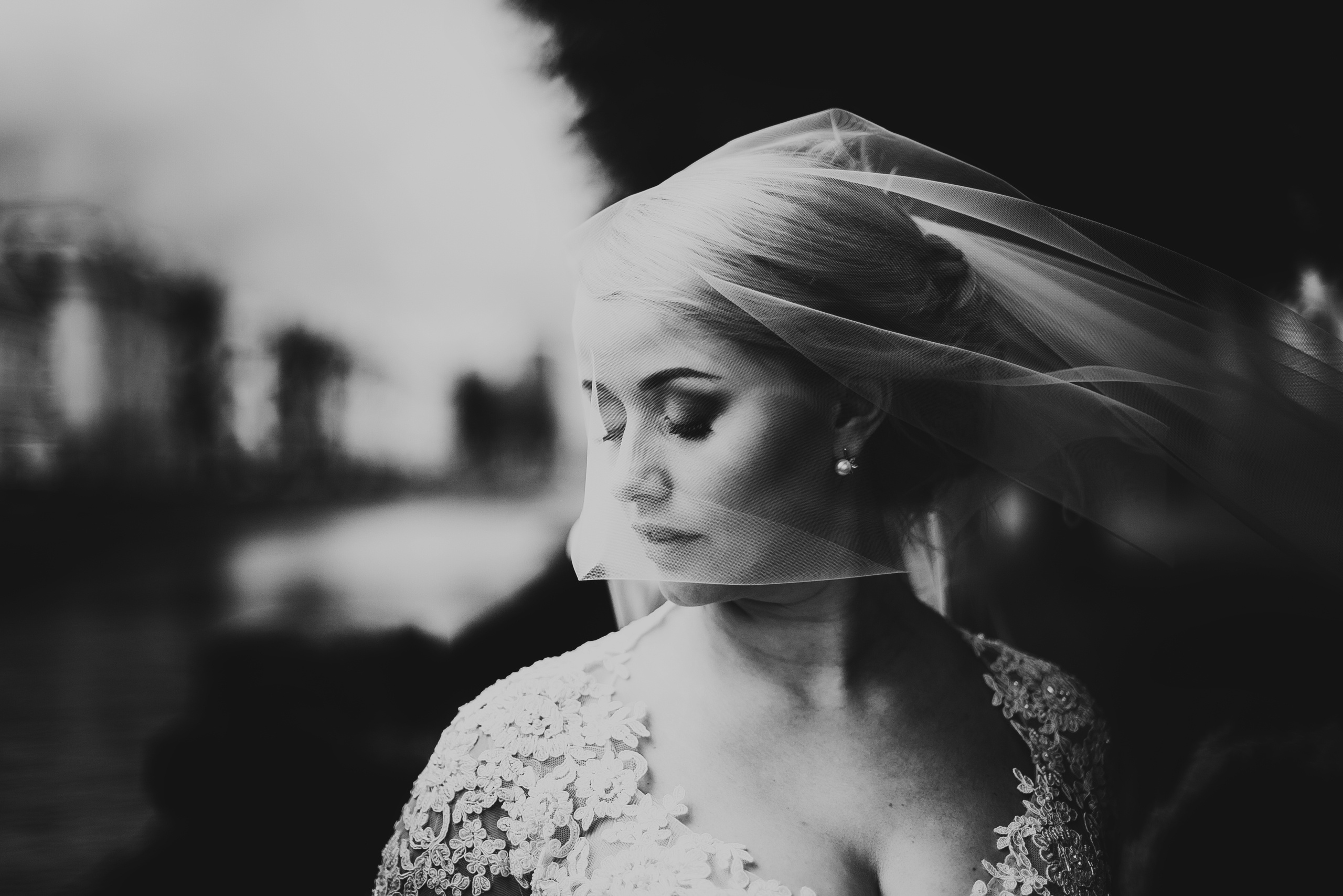 чёрно-белый портрет невесты с фатой на фоне города