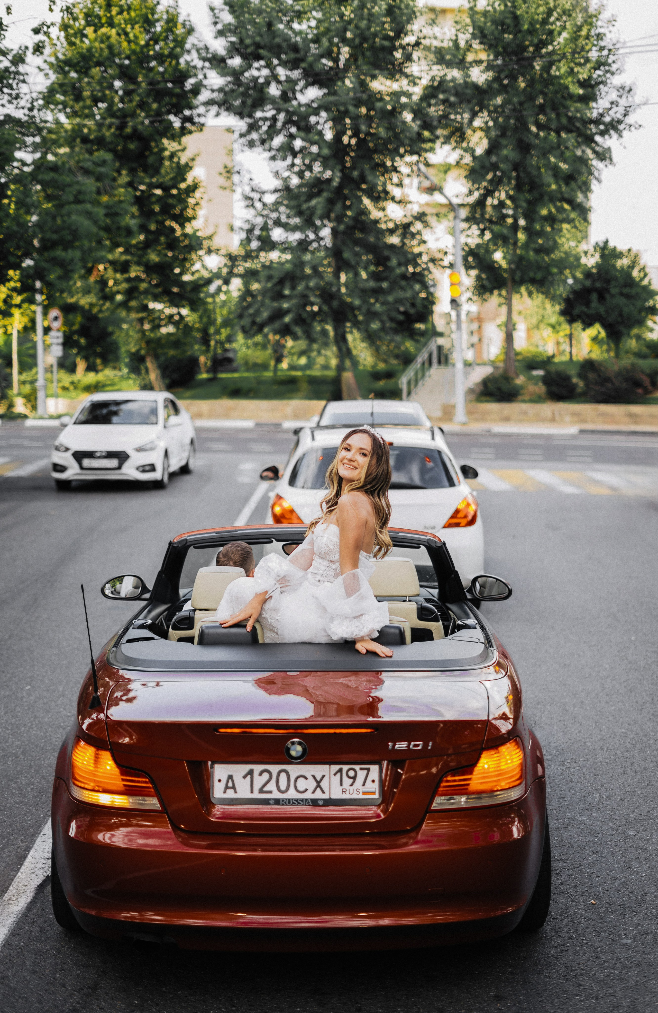 Красивая девушка на красной машине едет по Сочи