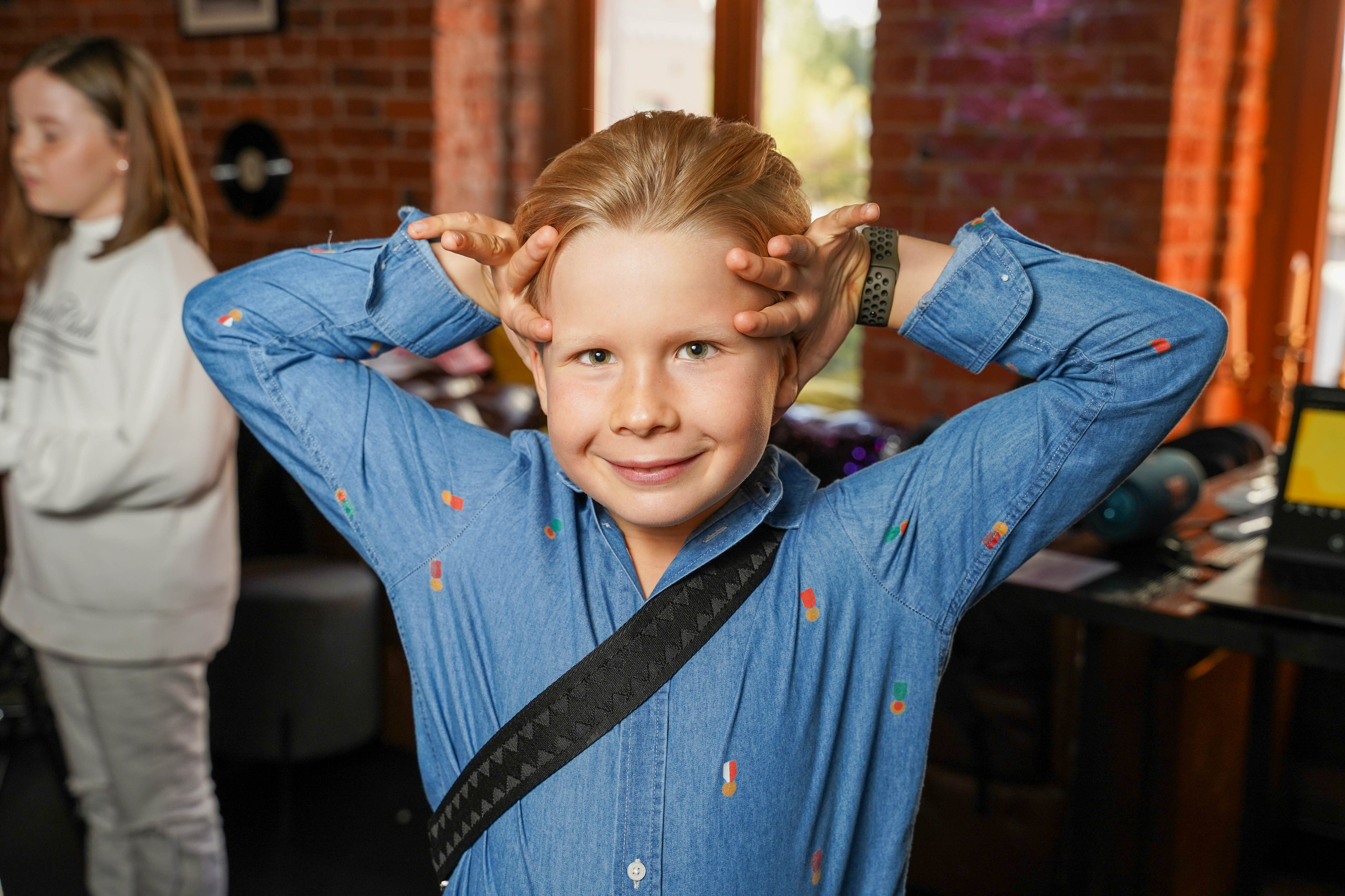 Мальчик с руками у головы на детском празднике