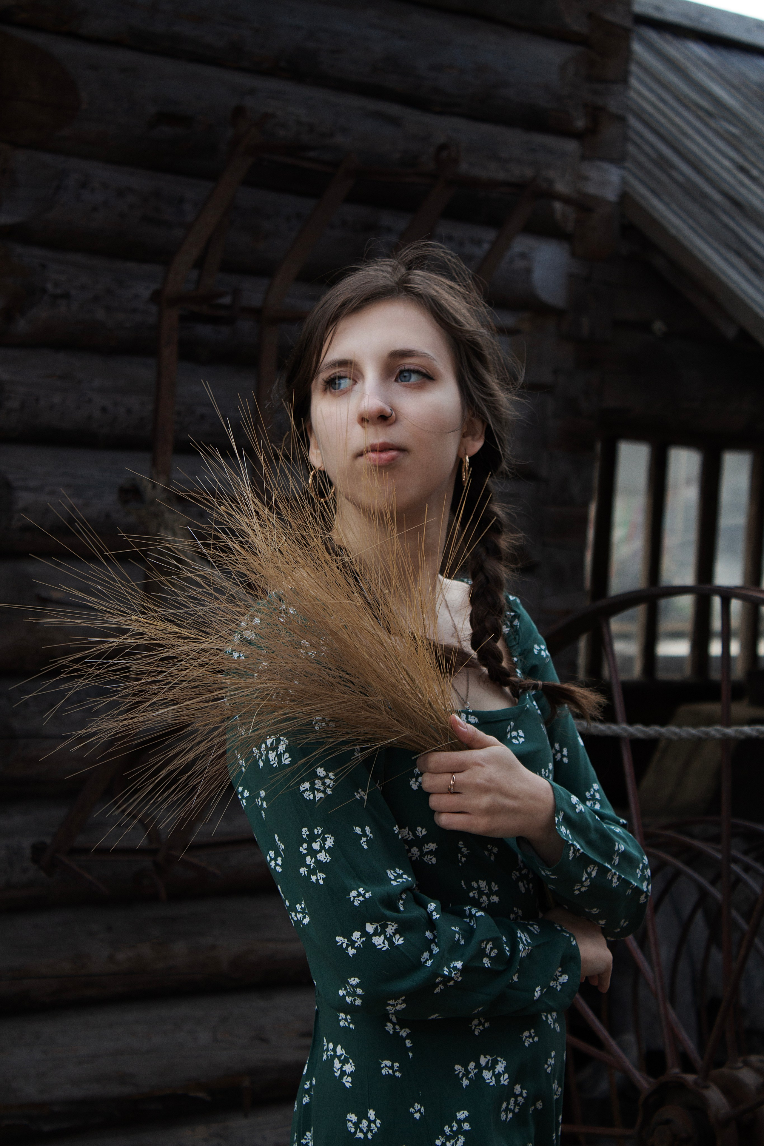 Девушка в платье с сеном на фоне деревни