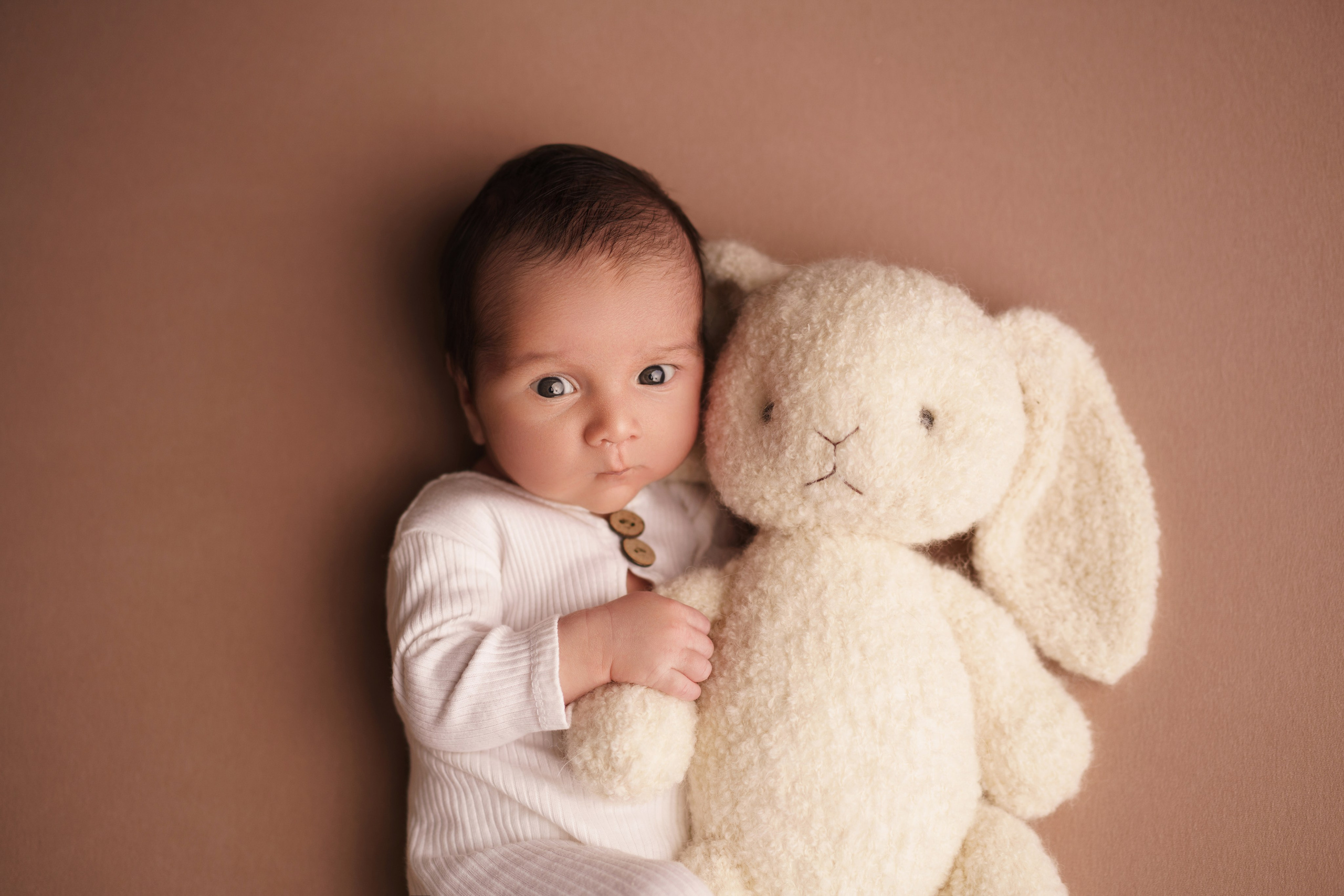 Малыш с открытыми глазками обнимает зайчика - трогательные кадры newborn