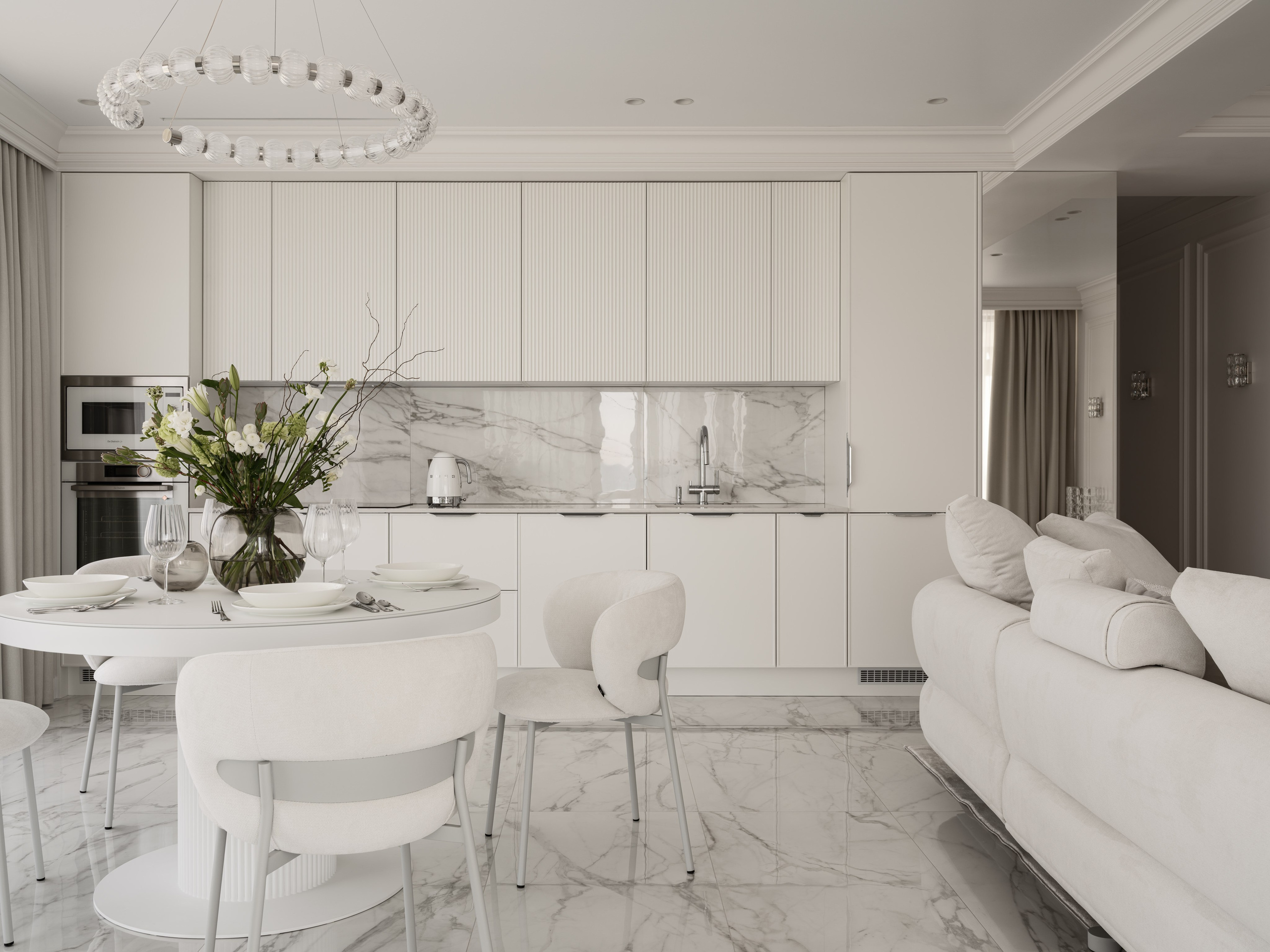 Современная кухня-столовая с белыми фасадами, мраморным фартуком и обеденным столом с цветочной композицией, элегантное сочетание мягких форм и светлого камня — проект дизайнера Алёны Боярской, стилист Наталья Якушева, фотограф Сергей Денисенко.