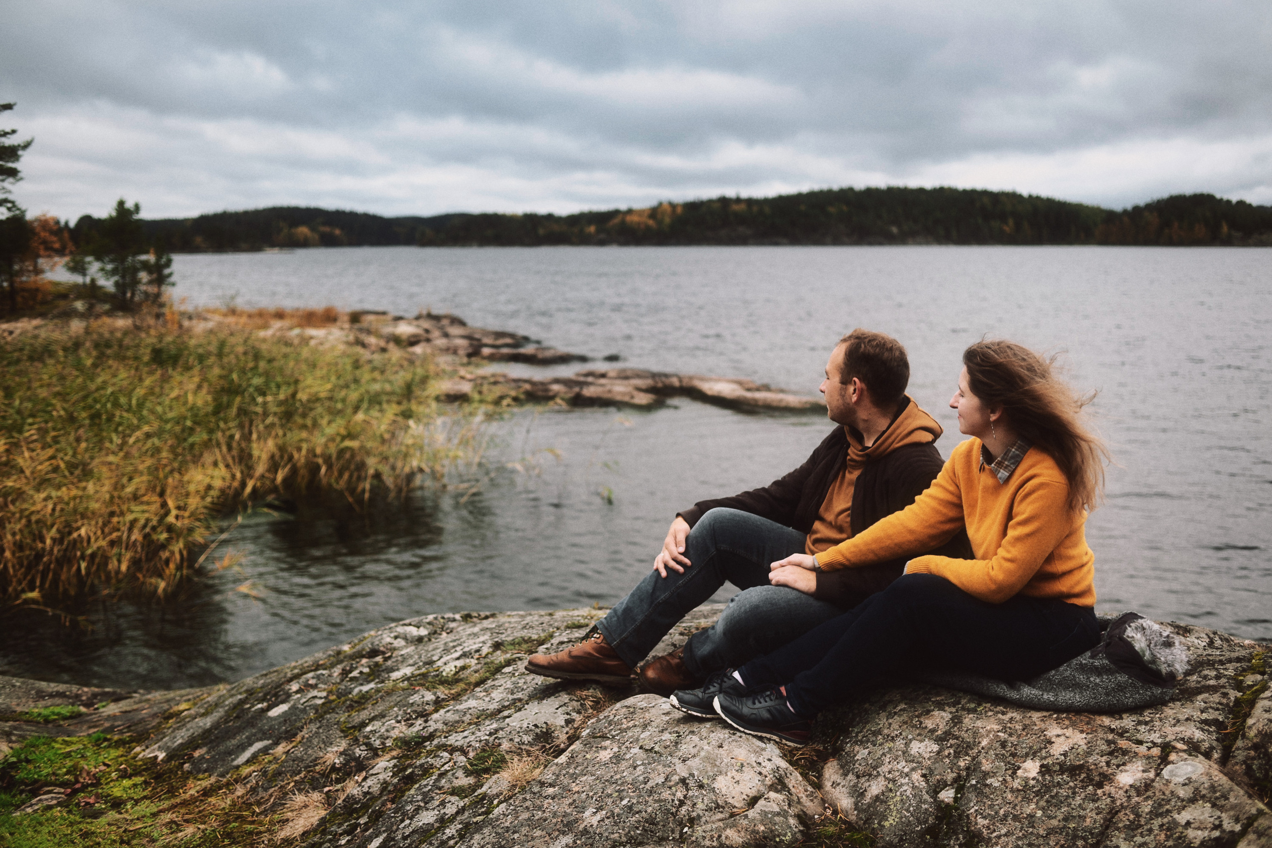 Влюбленная пара сидит на скалах в Карелии