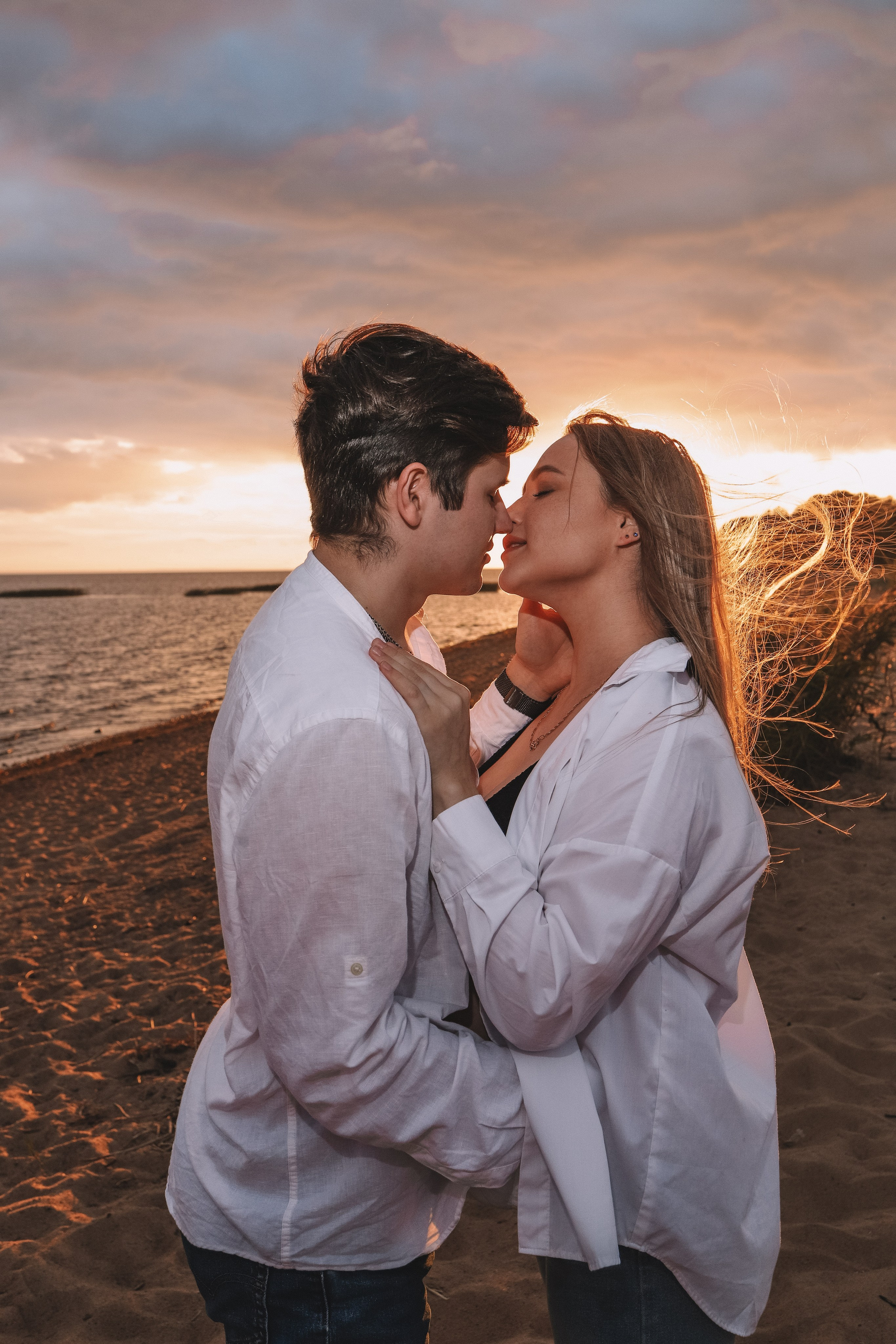 Пара обнимается на фоне заката