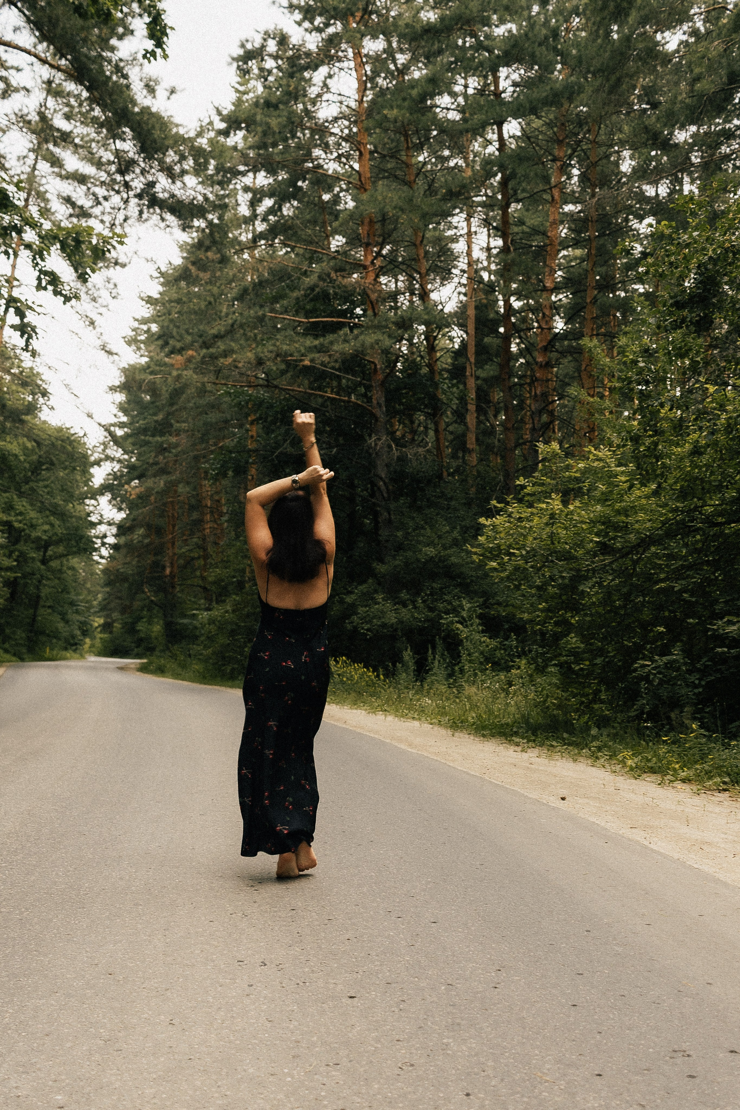 Девушка с поднятыми руками уходит вдаль по пустой дороге среди деревьев. Фотограф в Пензе Александра Овечкина