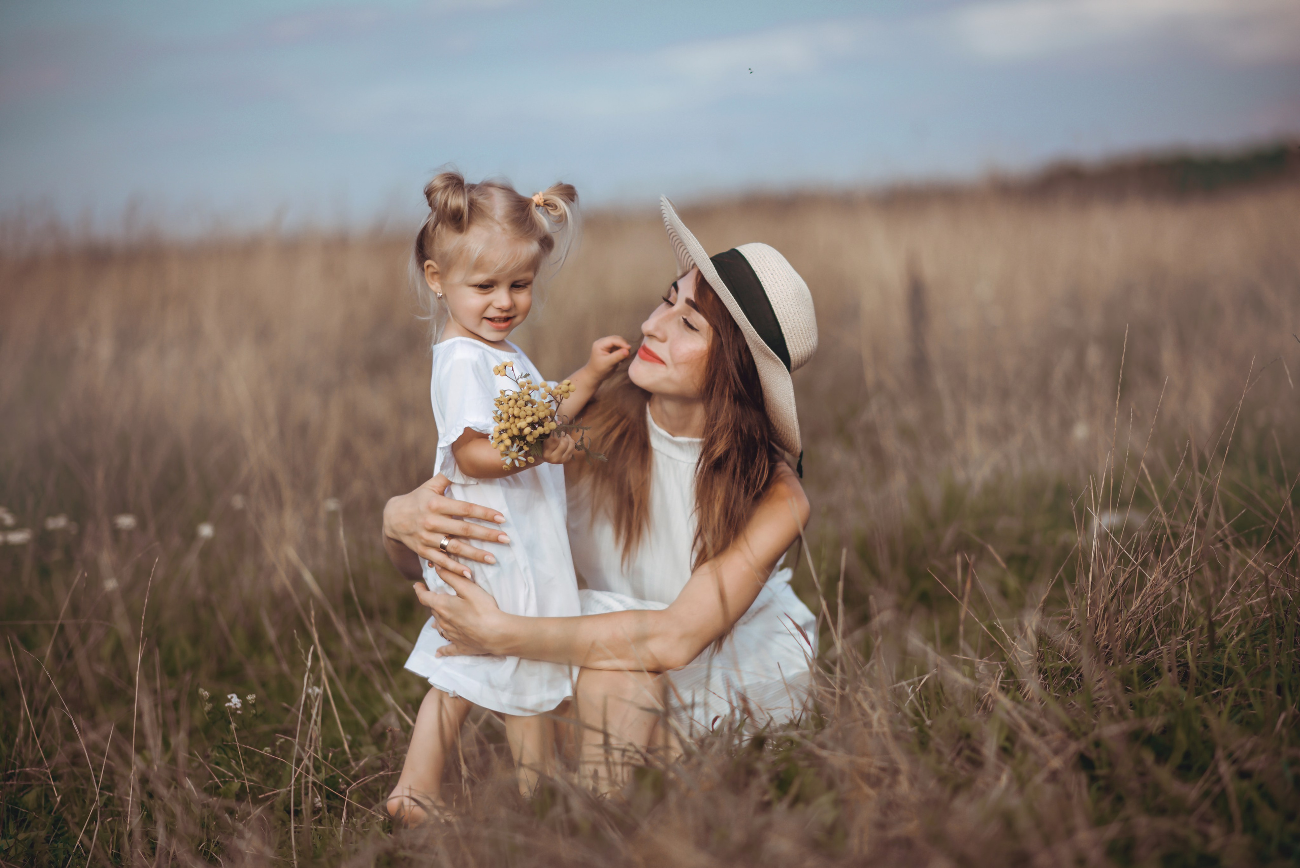 Mom sitting with her children in a meadow