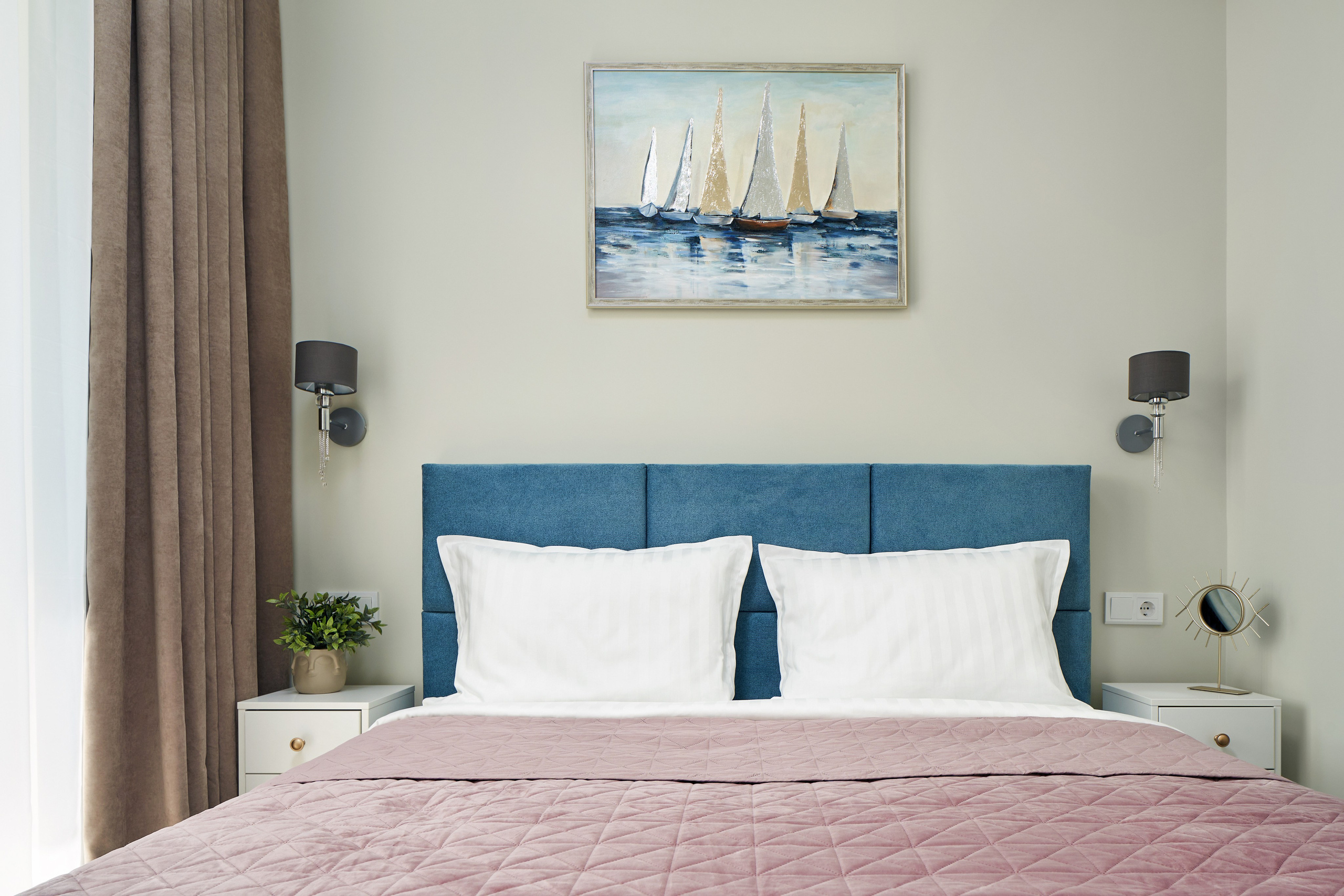 Спальня. Синее изголовье кровати, картина на стене приятные цвета