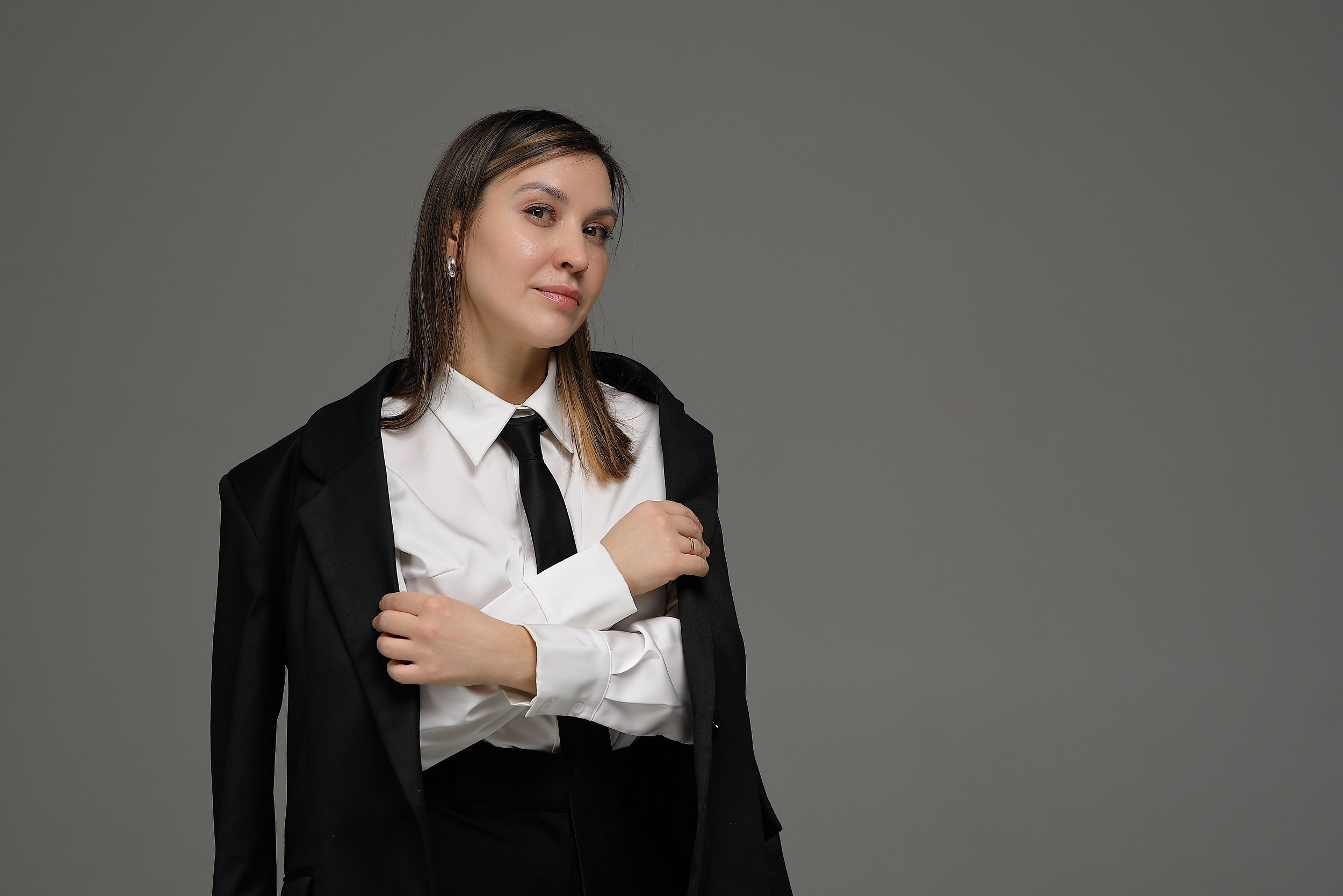 женщина в черном костюме на белом фоне в деловом стиле
