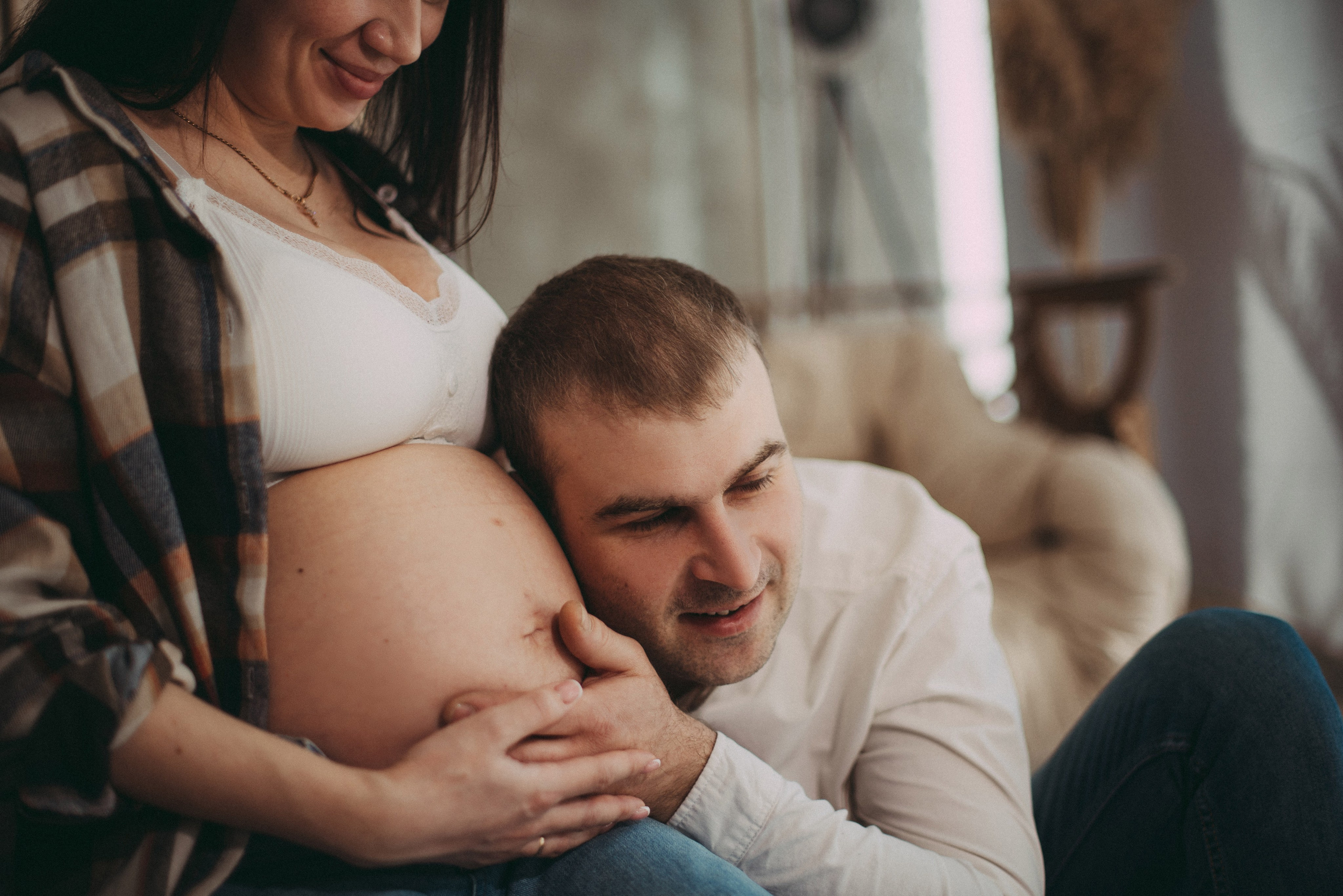 папа слушает животик в ожидании малыша