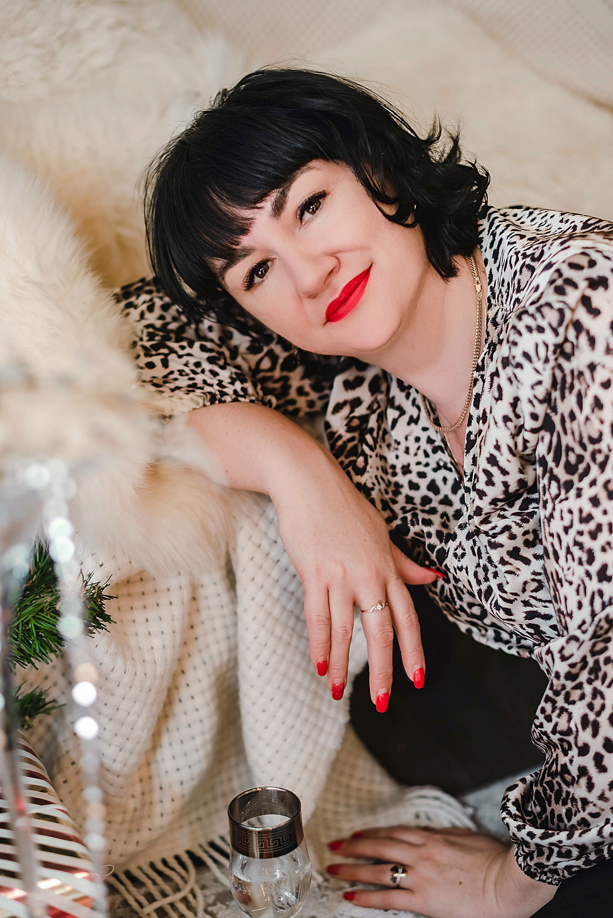 На фото  портрет девушки с подарком сидит около дивана.