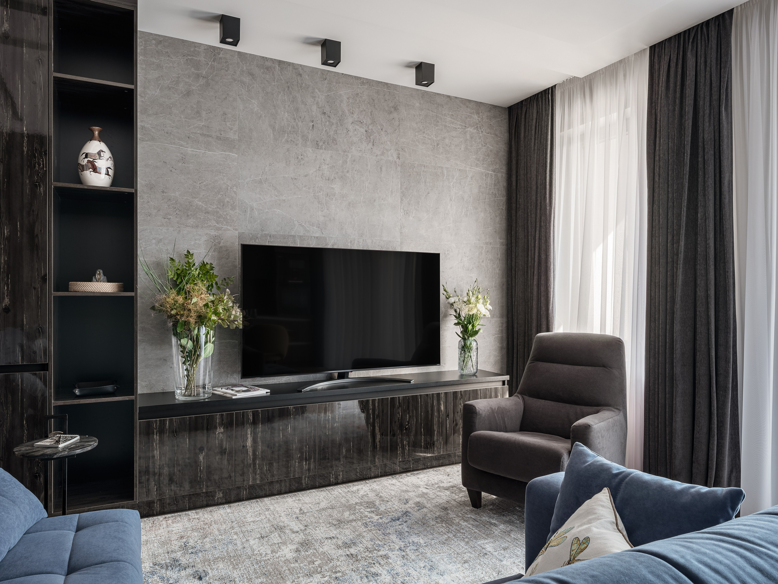 Уютная гостиная с большой телевизионной зоной, серым креслом и акцентом на каменную стену, интерьер Алёны Поповой и Анастасии Дмитриевой, фото Сергея Денисенко.