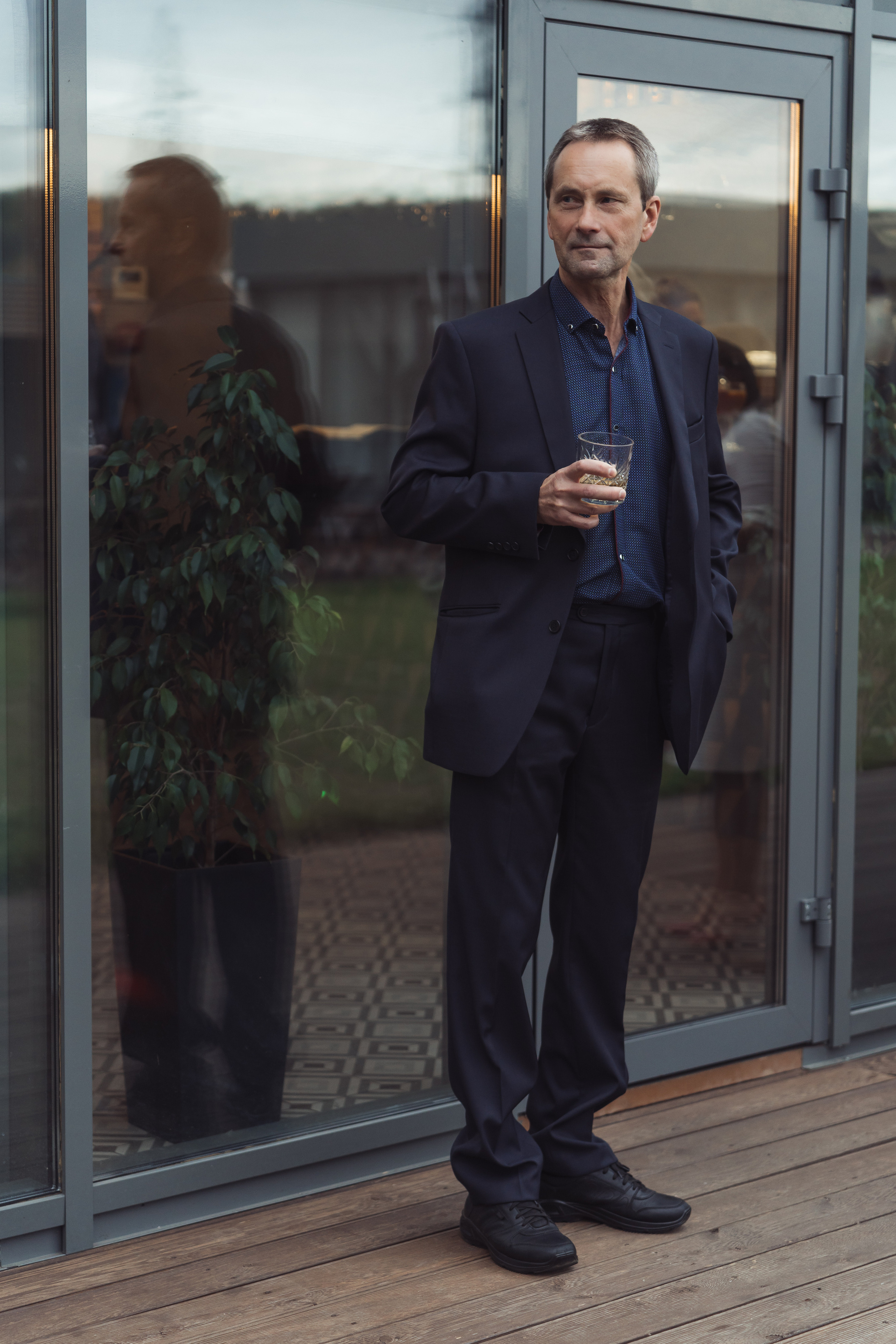 Отец жениха в костюме поздравляет молодых жениха и невесту