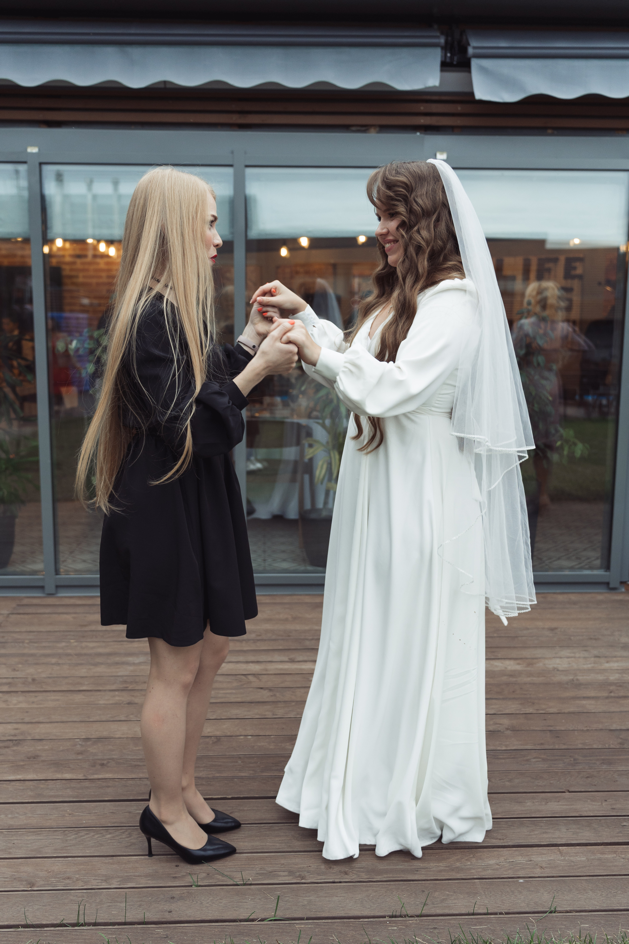 Подружка невесты в черном платье и туфлях танцует 