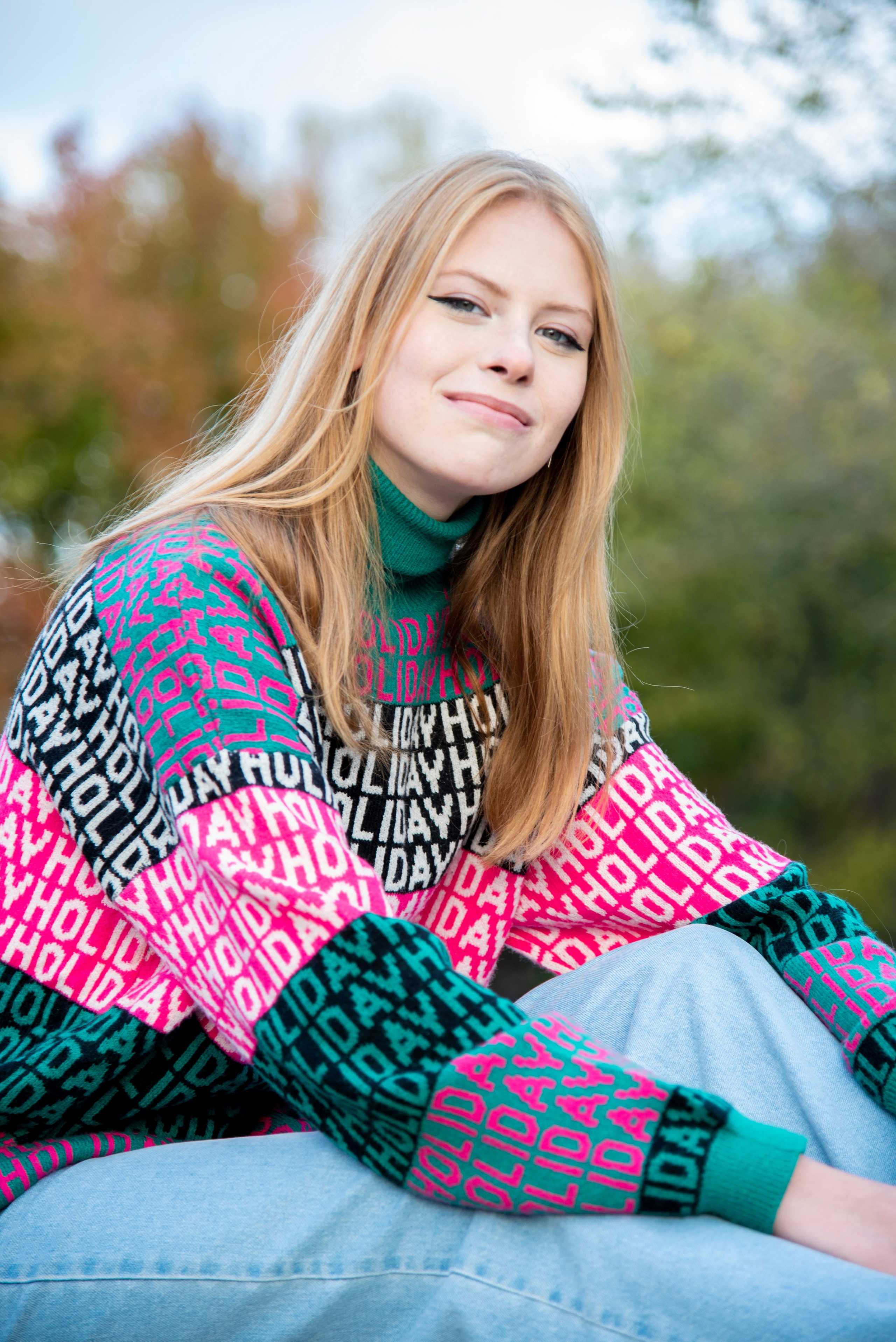 молодая девушка студентка. блондинка. длинные волосы. розово-зелёный свитер. парк Лога . осень