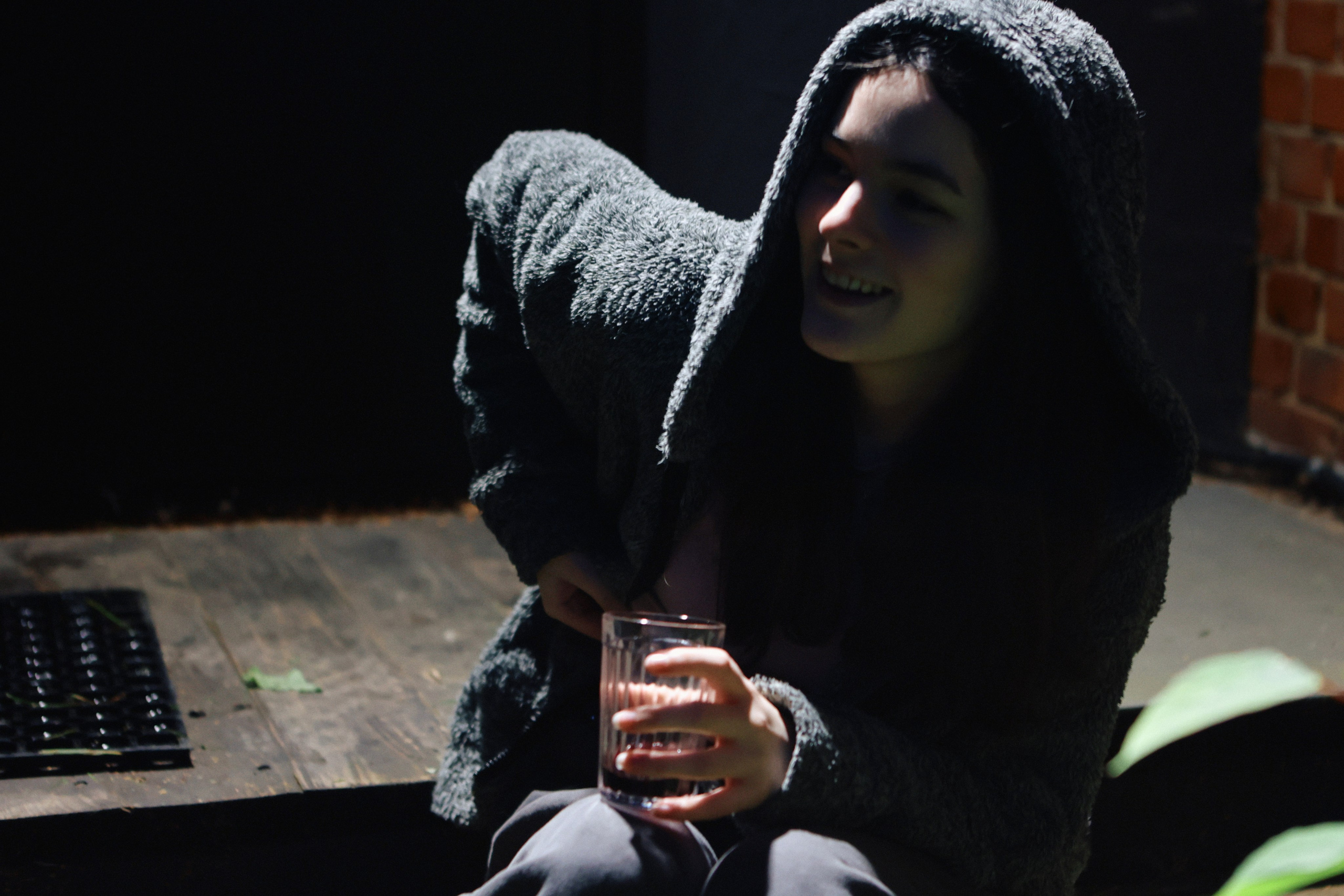 девушка сидит на крыльце со стаканом