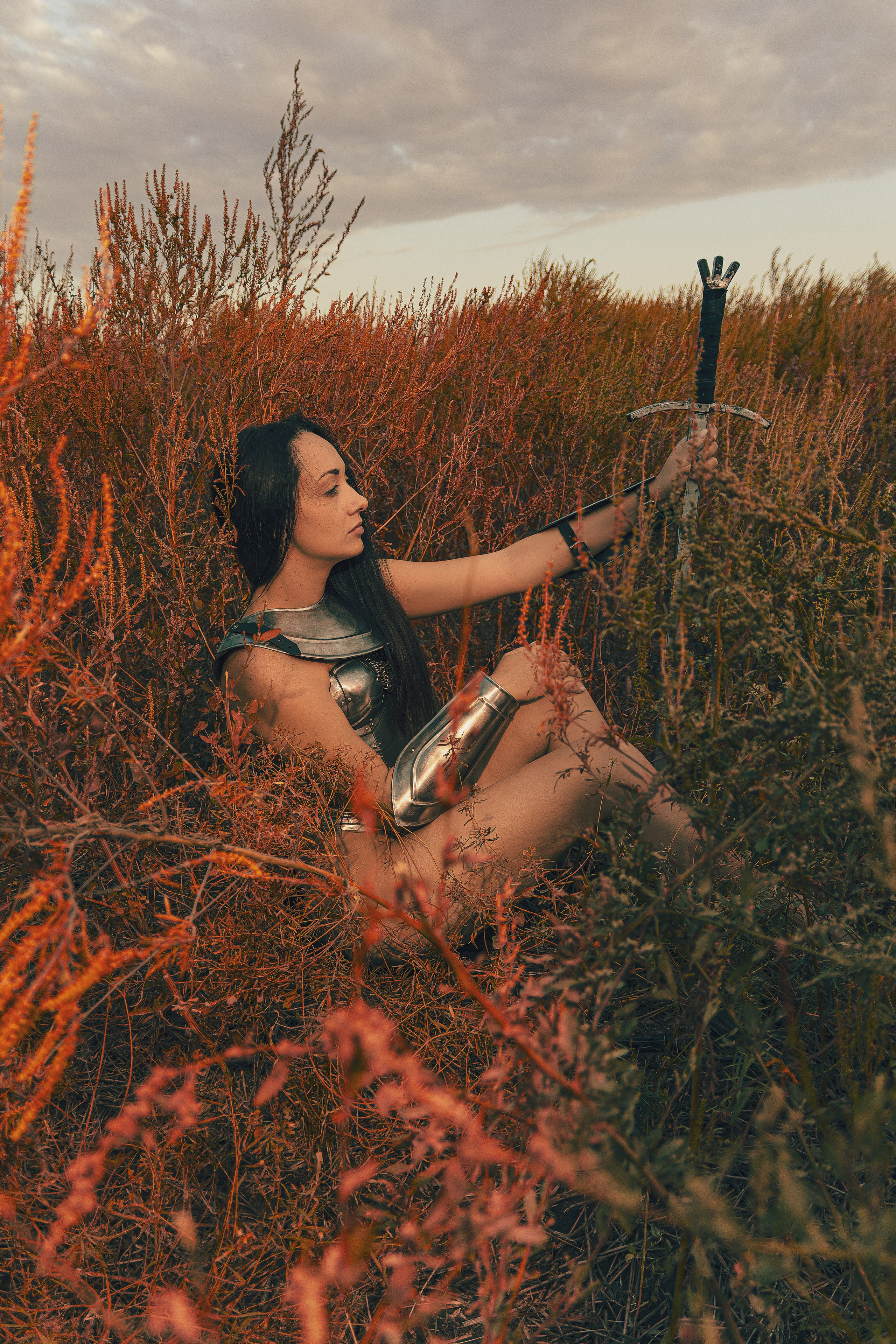 Женская фотосессия в Ростове-на-дону в образе воительницы с доспехами и мечом в поле. Ню фотосессия в Ростове-на-Дону.