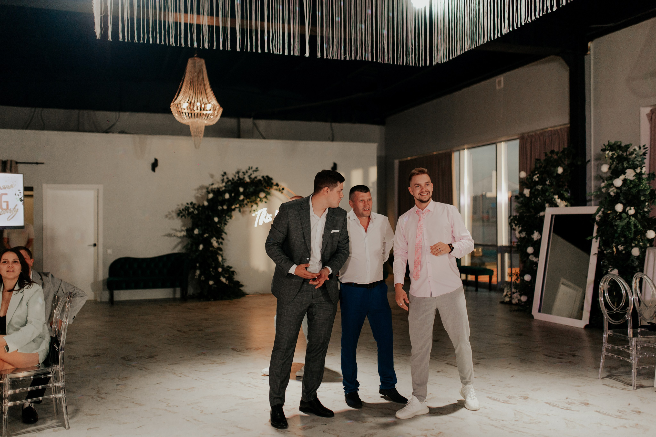 Друзья смеются в зале торжества — искренние эмоции