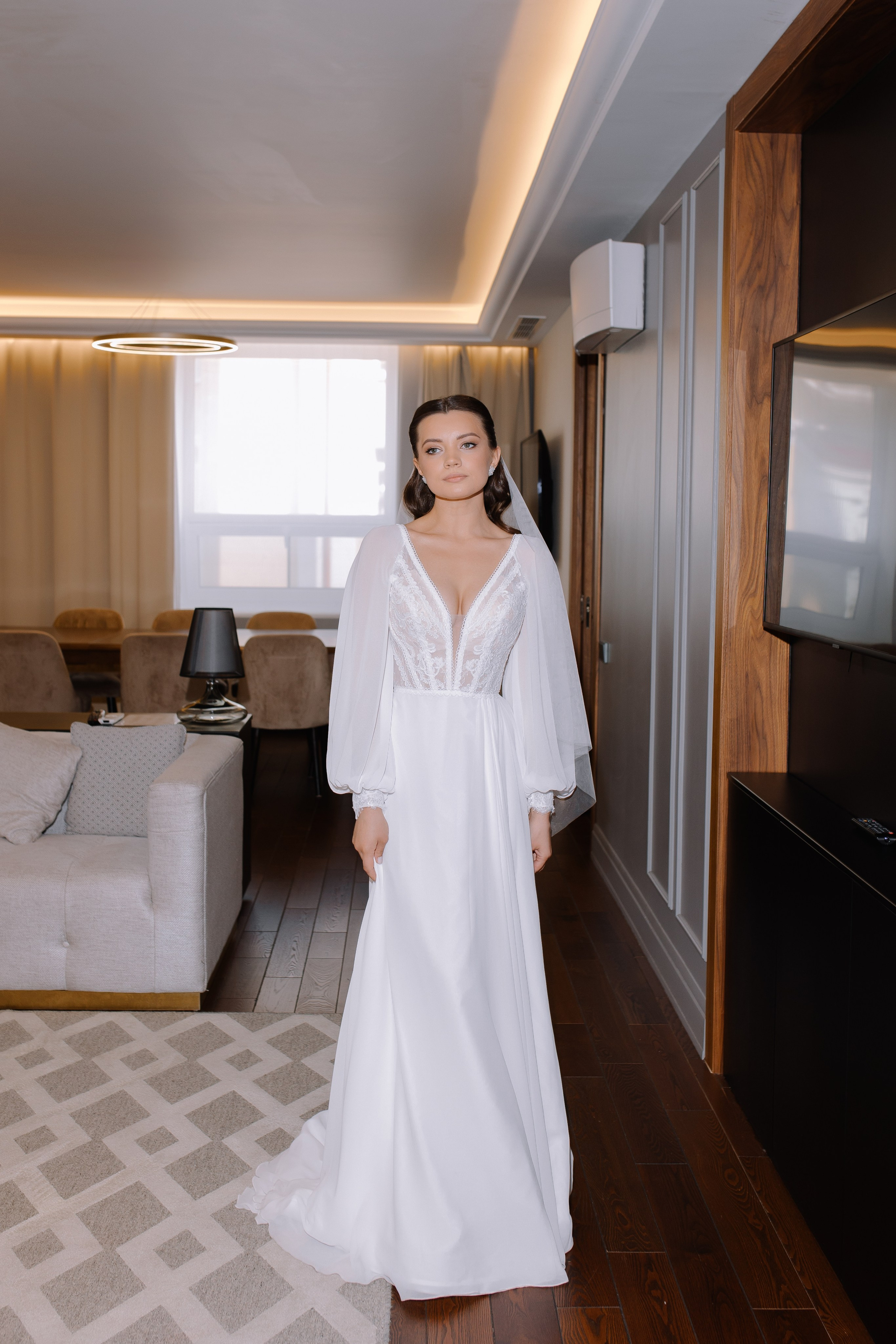 Стильный интерьер номера с большим окном, выходом на балкон с потрясающим видом на город.