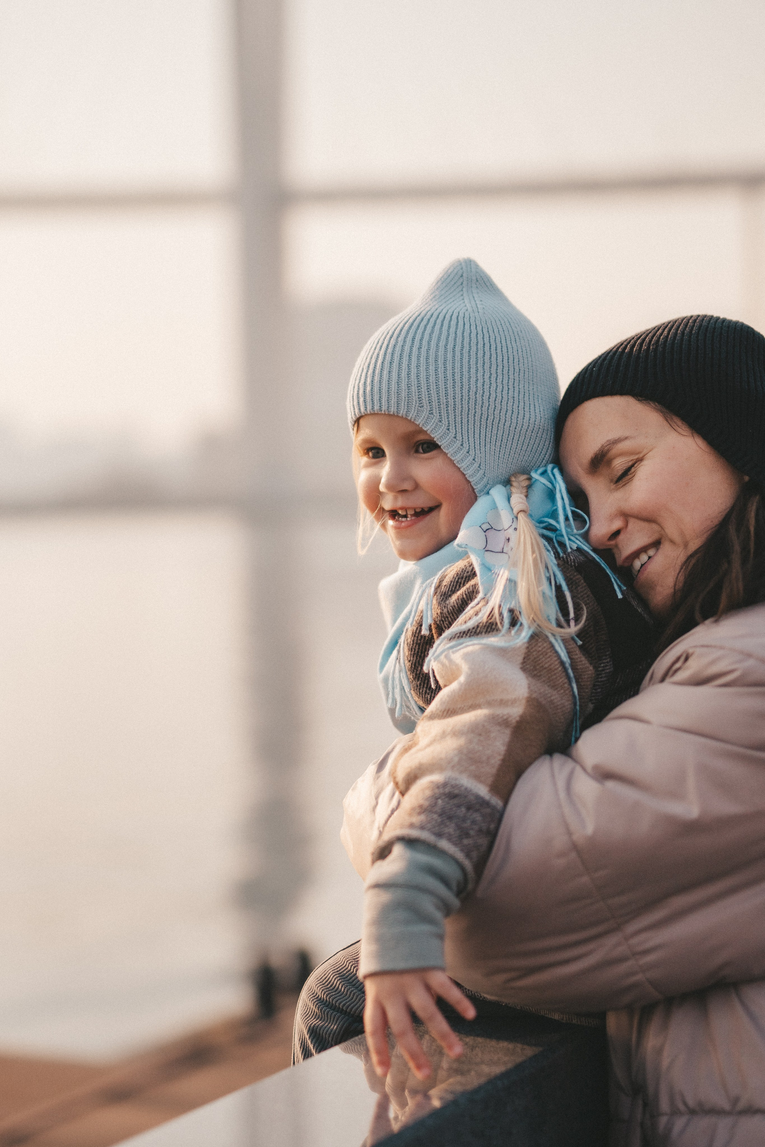 мама и маленькая дочка крупным планом обнимаются на улице
