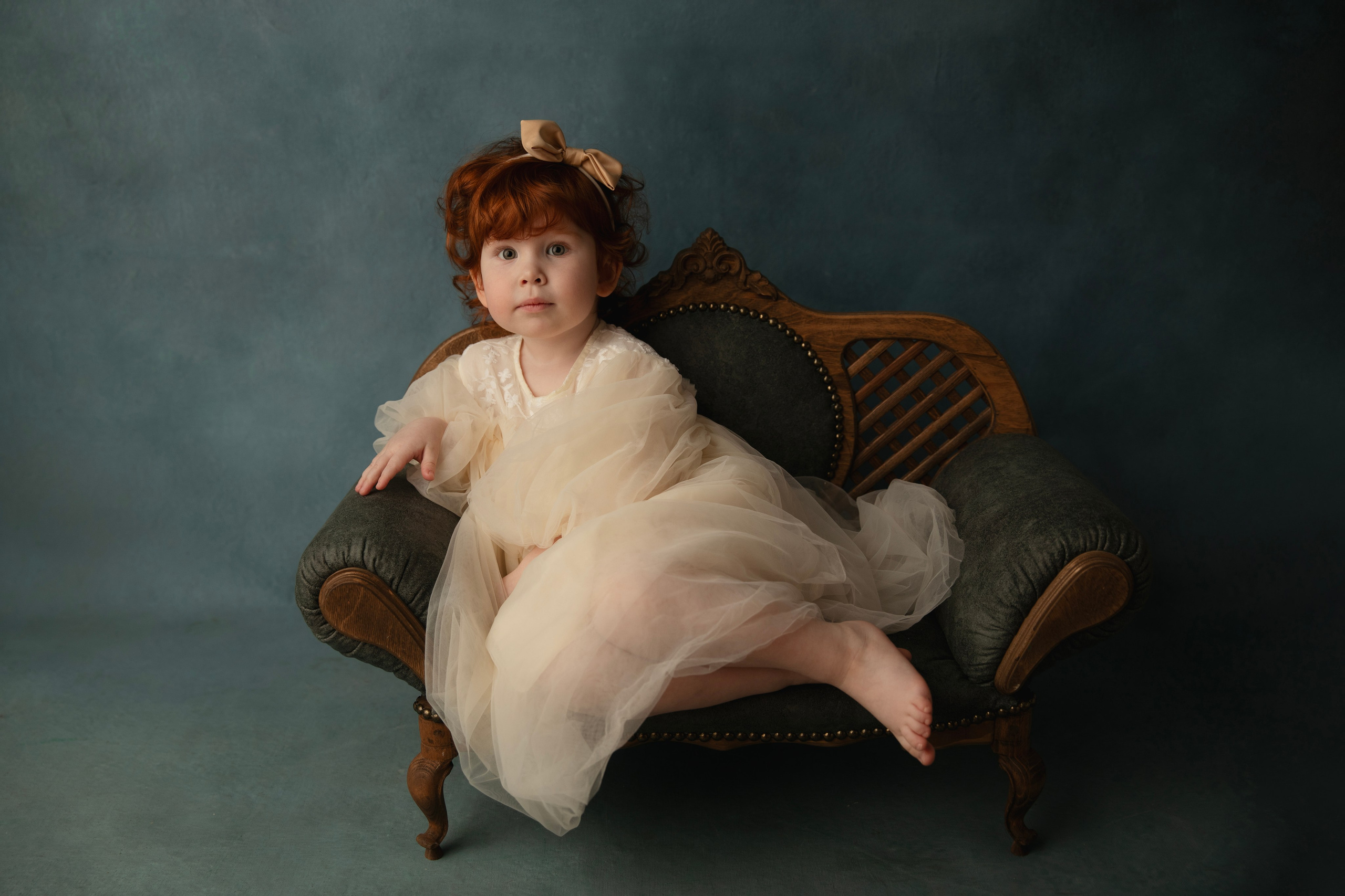 «Детская, художественная съемка в студии — девочка в белом платье на красивом диване»