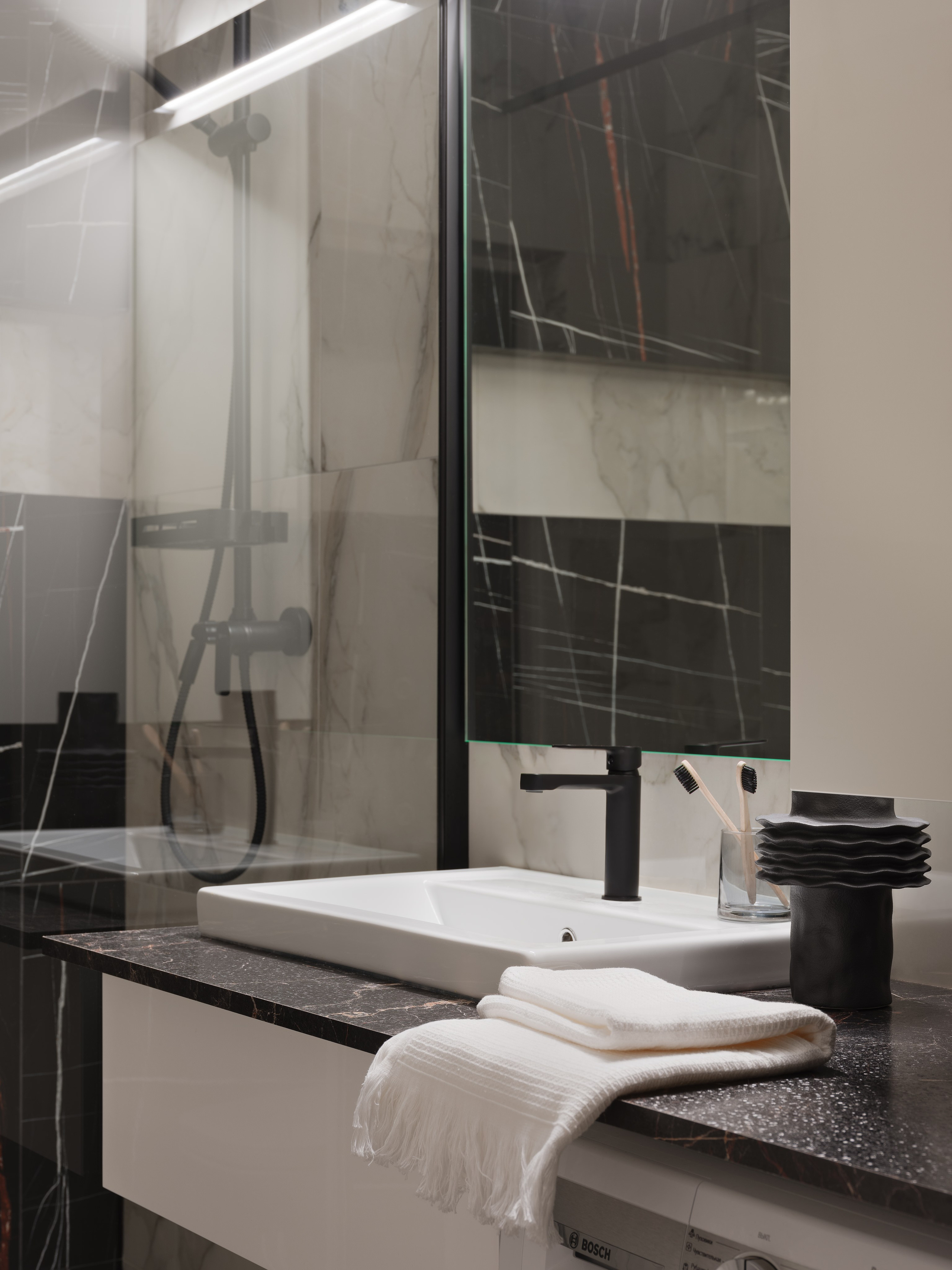 Интерьер современной ванной комнаты с контрастной плиткой под мрамор, черной сантехникой и стильным декором, уют и гармония, фото дизайнера Ольги Рубченко, стилиста Екатерины Ракитиной и фотографа Сергея Денисенко.