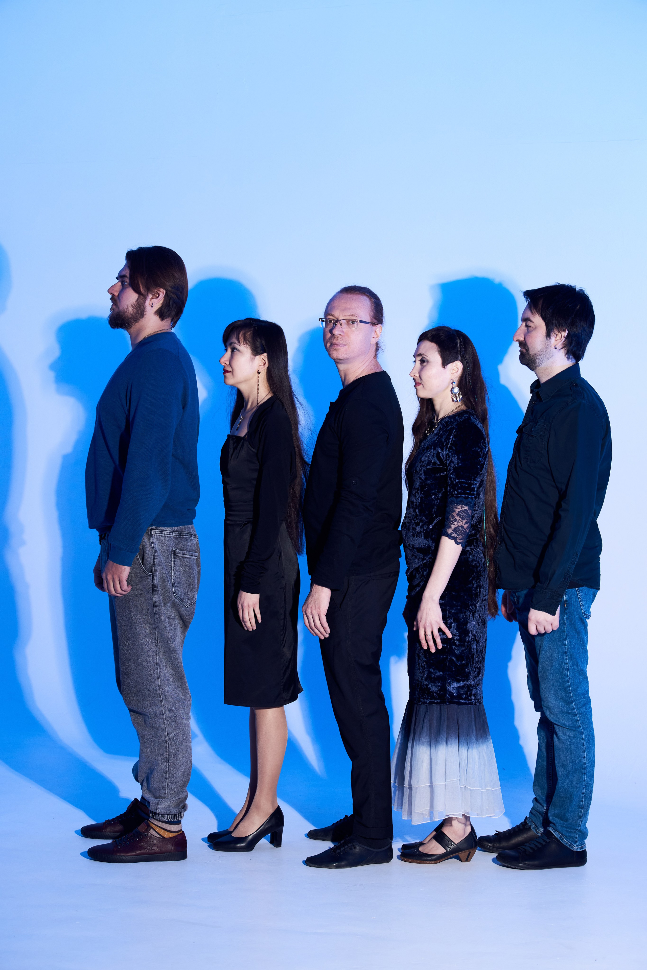 Групповое фото пяти человек с лентами и цветным светом