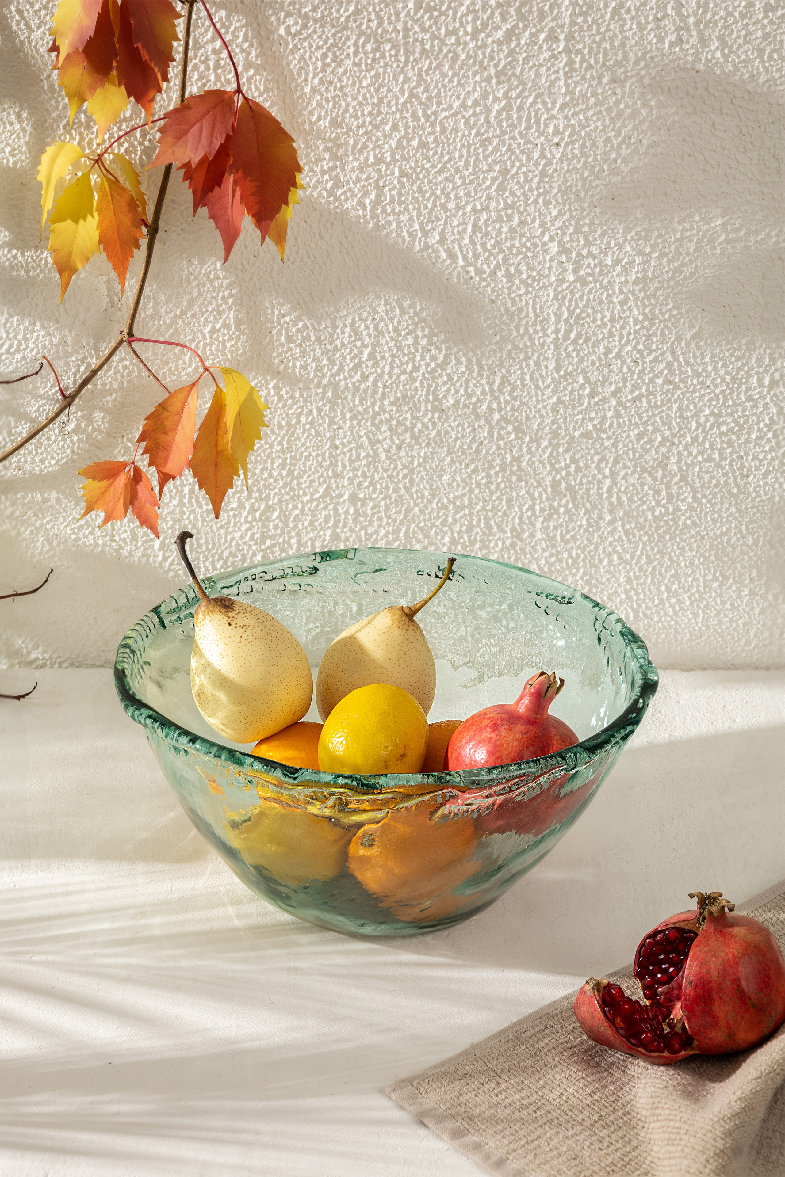 Стеклянная ваза с фруктами у стены на солнце | Фото для каталога домашнего декора