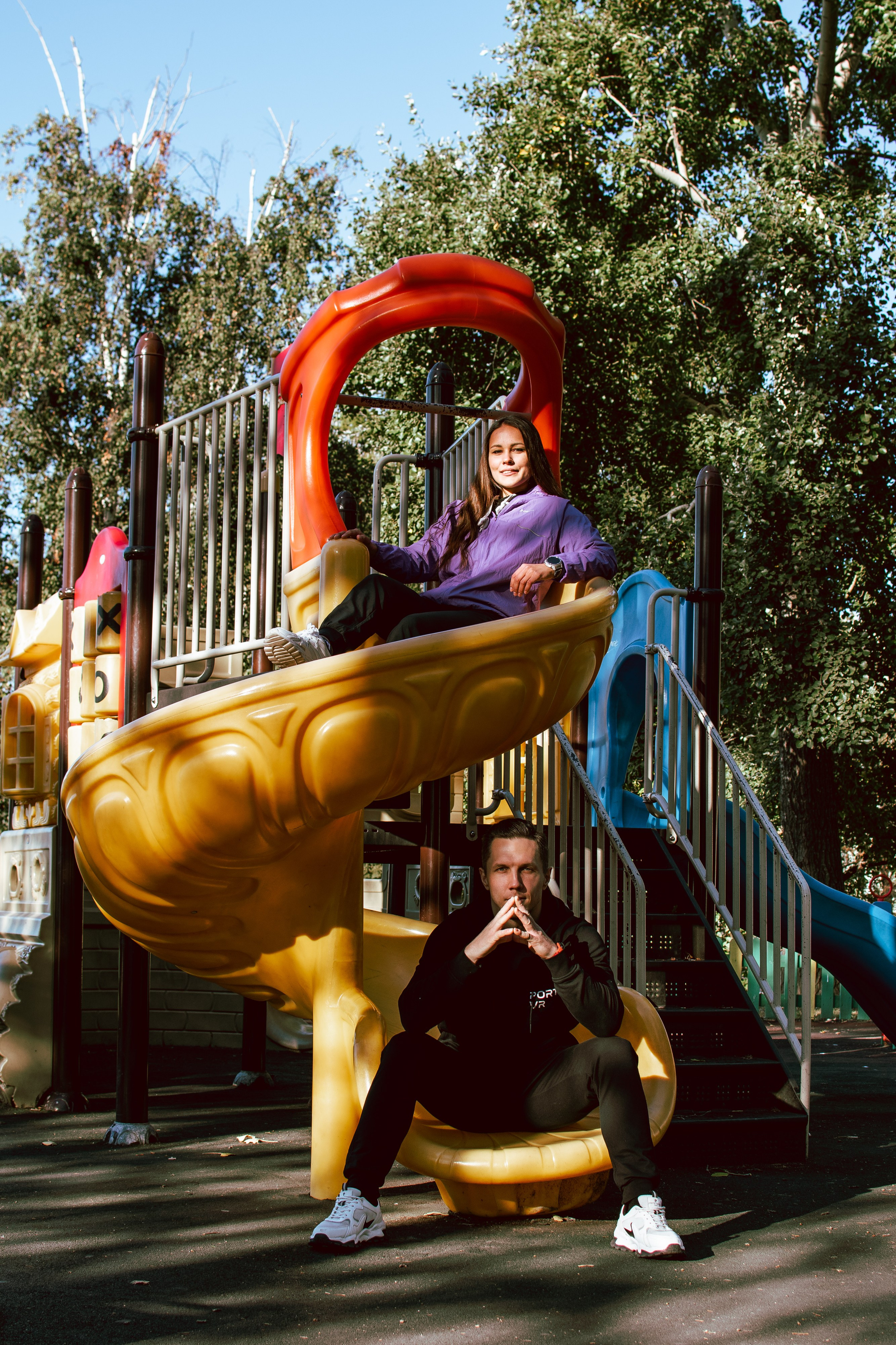 Парень и девушка отдыхают на горке на детской площадке