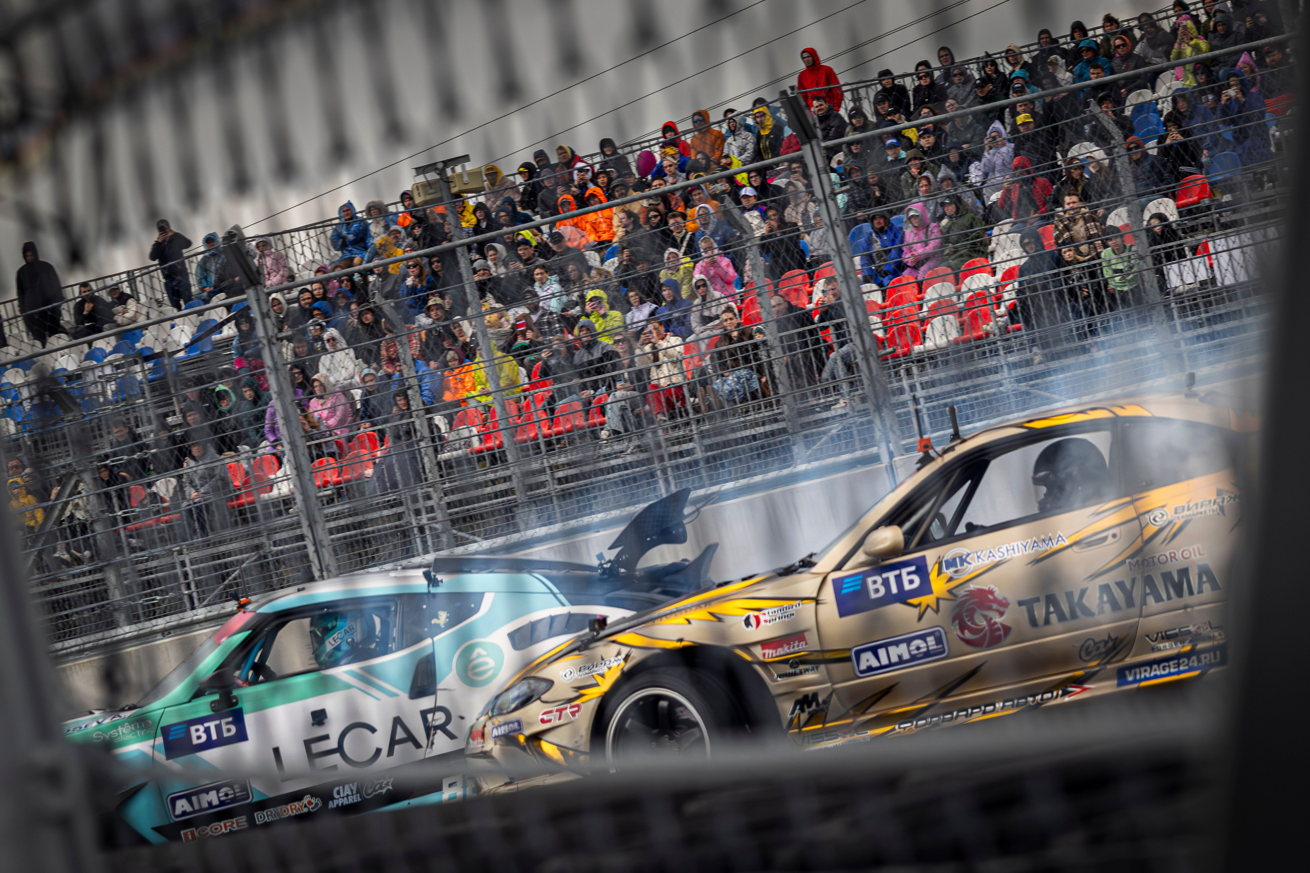 Болельщики аплодируют, когда автомобиль эффектно проходит поворот.