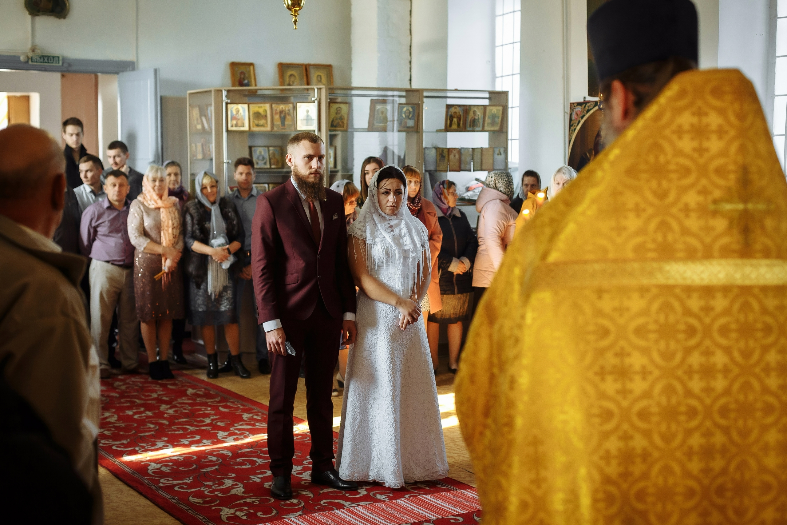 батюшка читает молитву над парой венчание