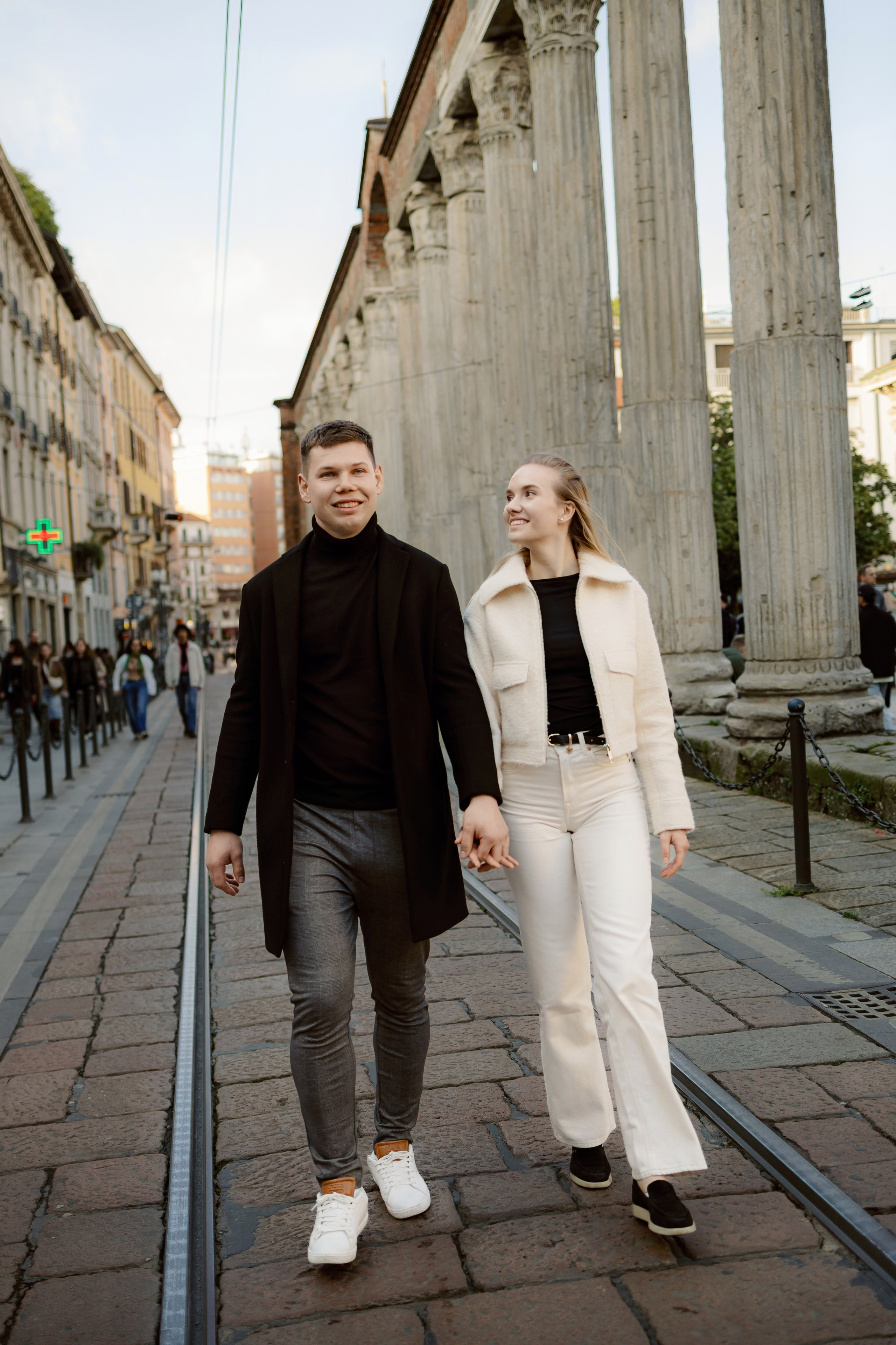 Пара идёт по старой улочке, непринуждённо и со вкусом