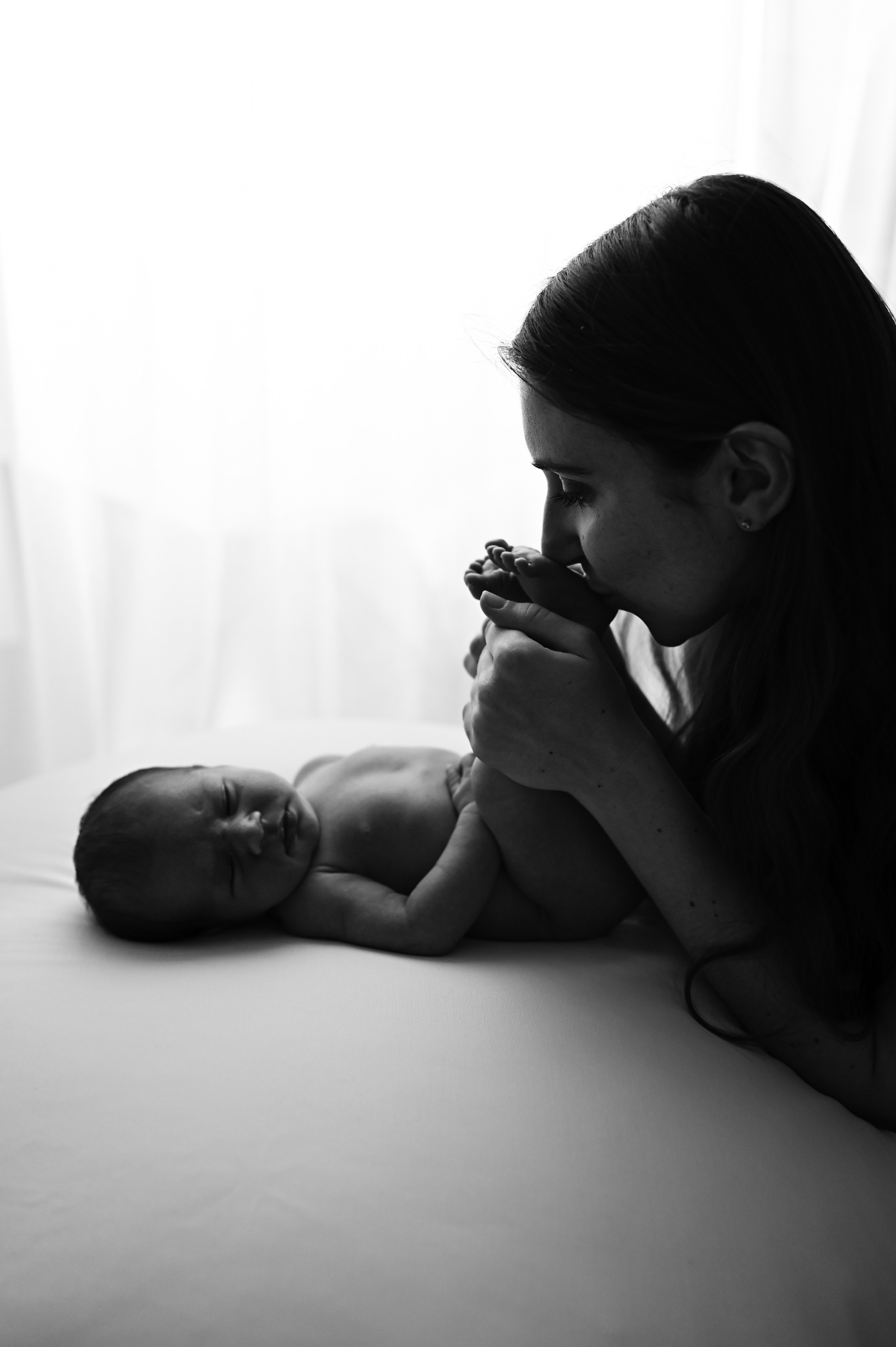 мама целует пяточки своего ребенка