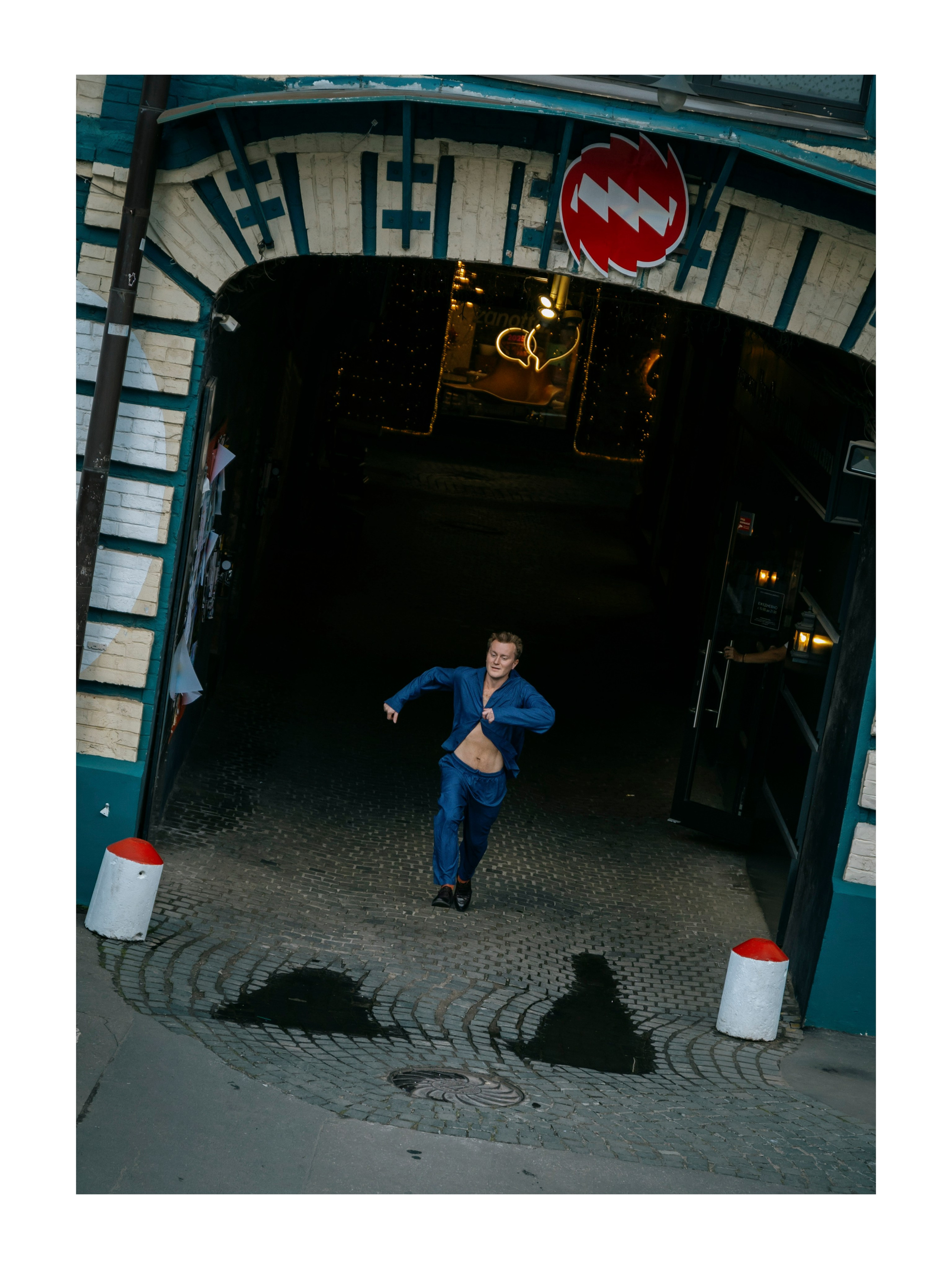 мужчина выбегает из арки на улице