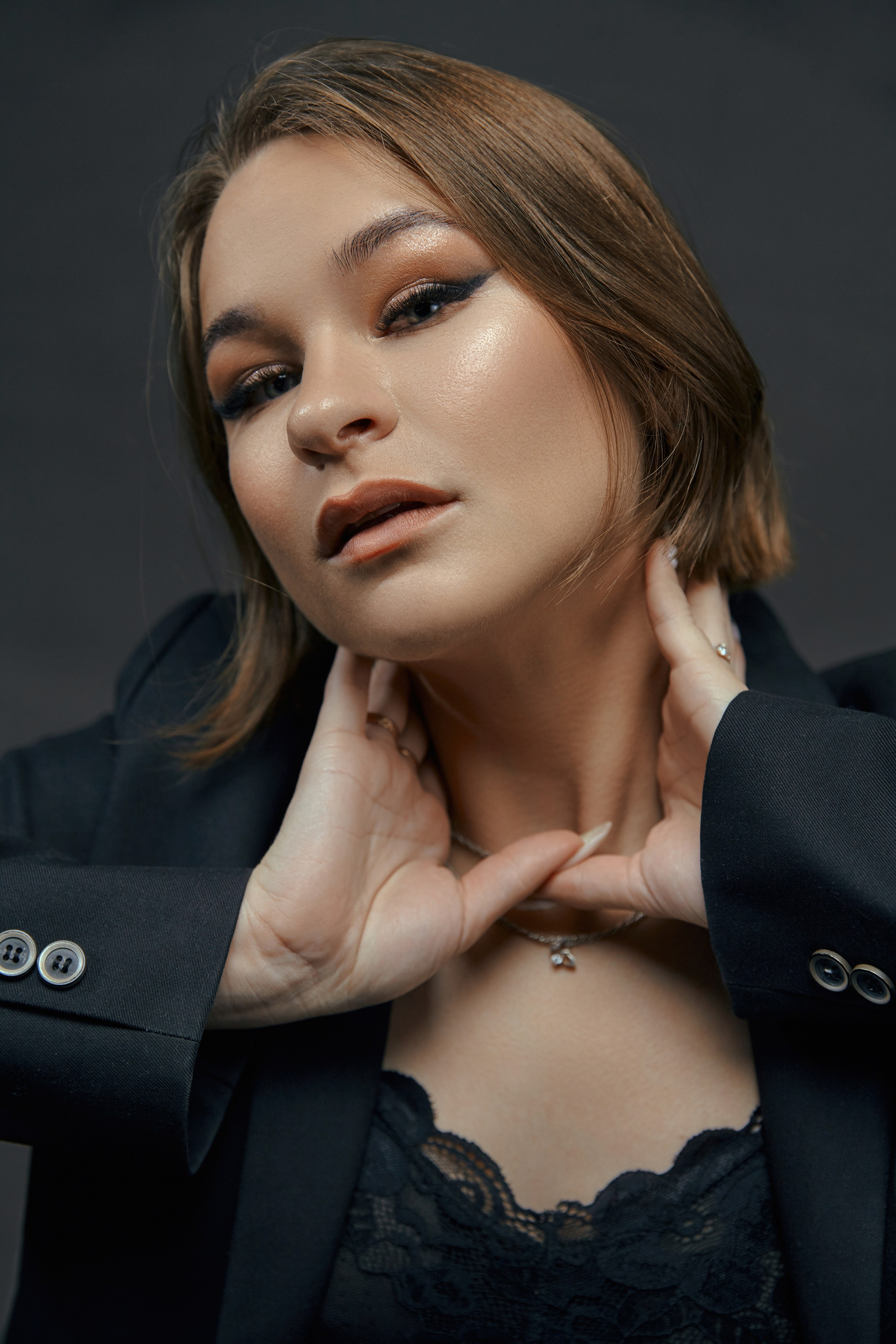 Крупный портрет шатенки в студии на темном фоне