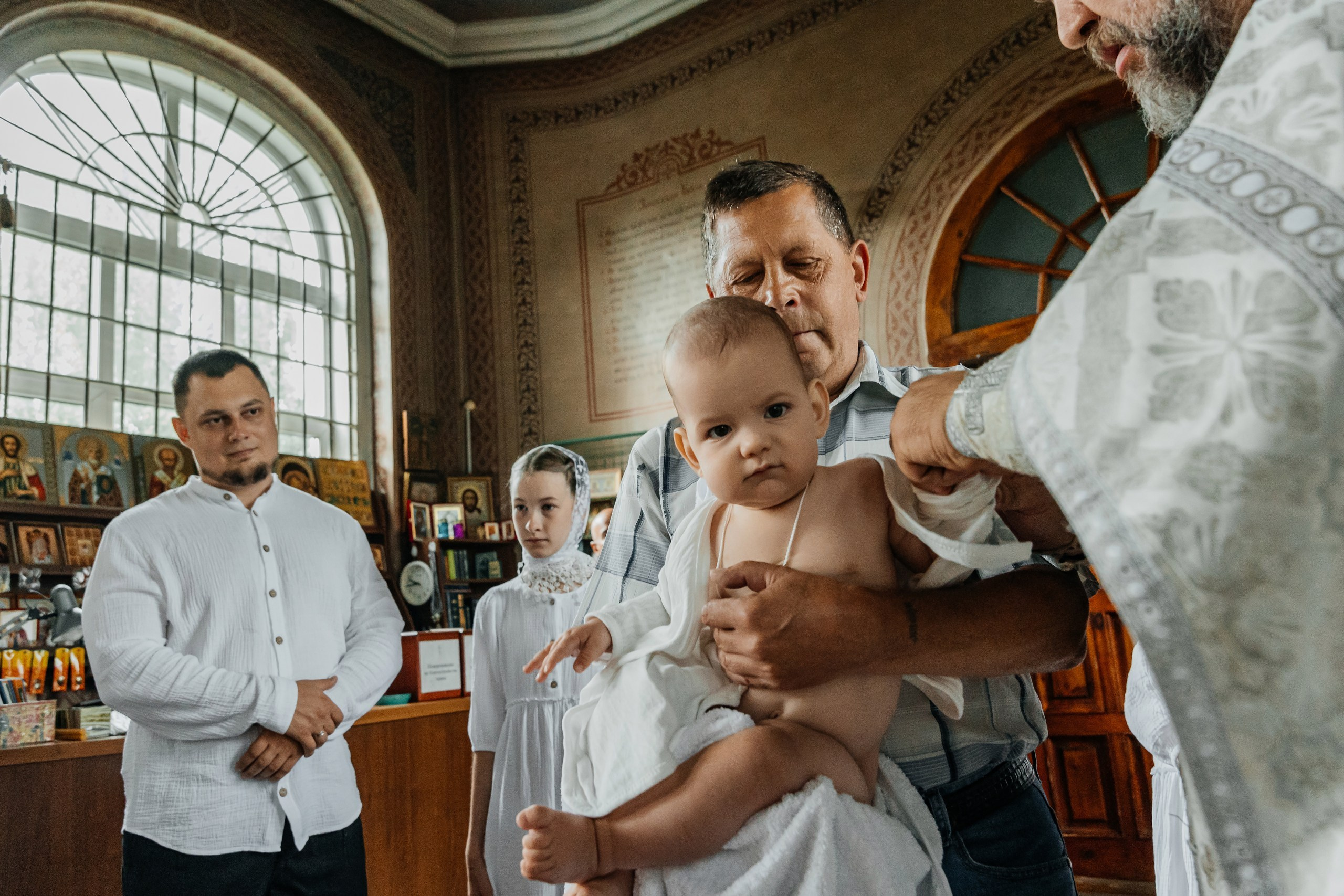 Таинство крещения, священник отец Михаил держит ребёнка