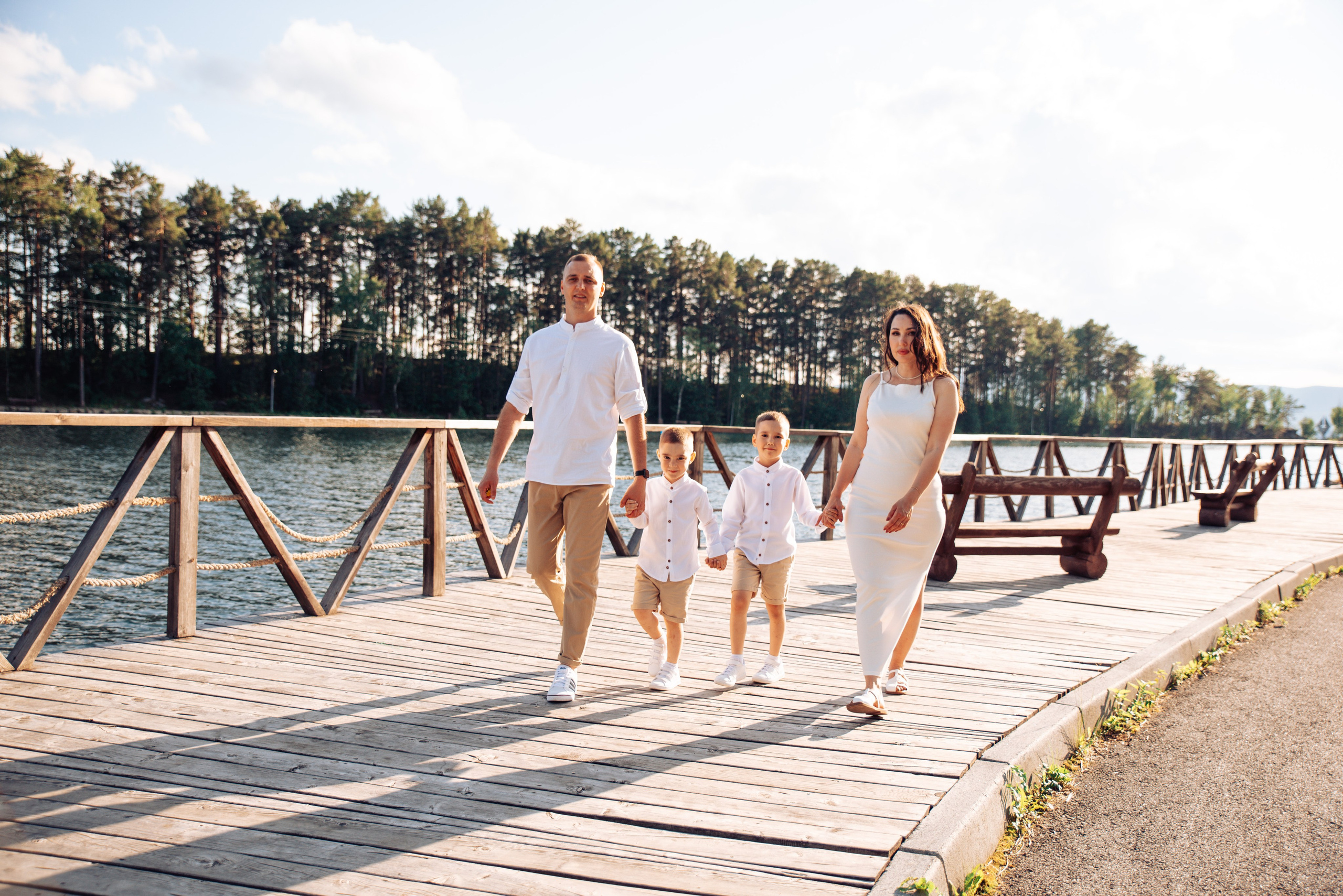 Семейная прогулка летом на берегу озера по пляжу