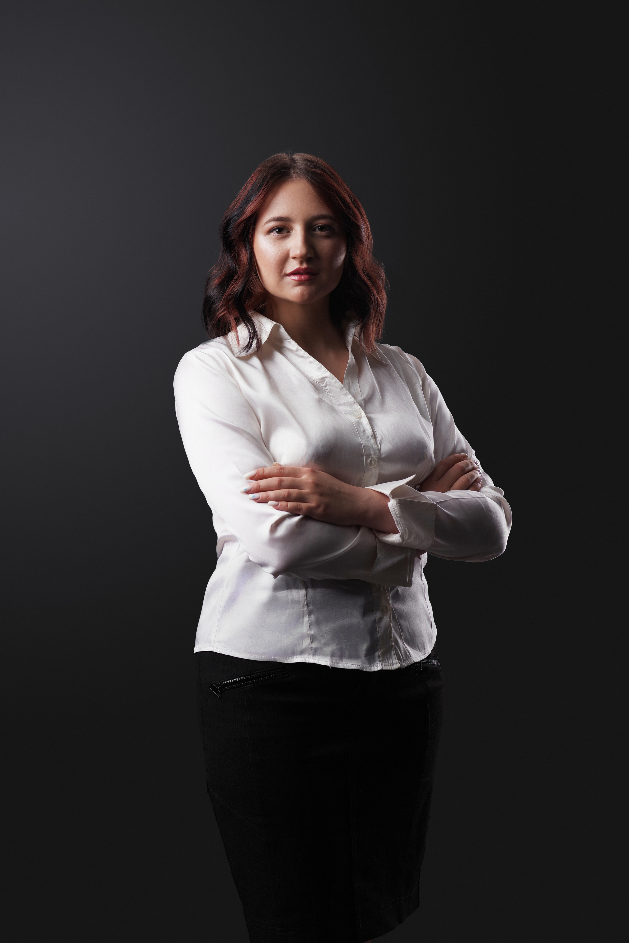 Деловой портрет молодой женщины в белой блузке.