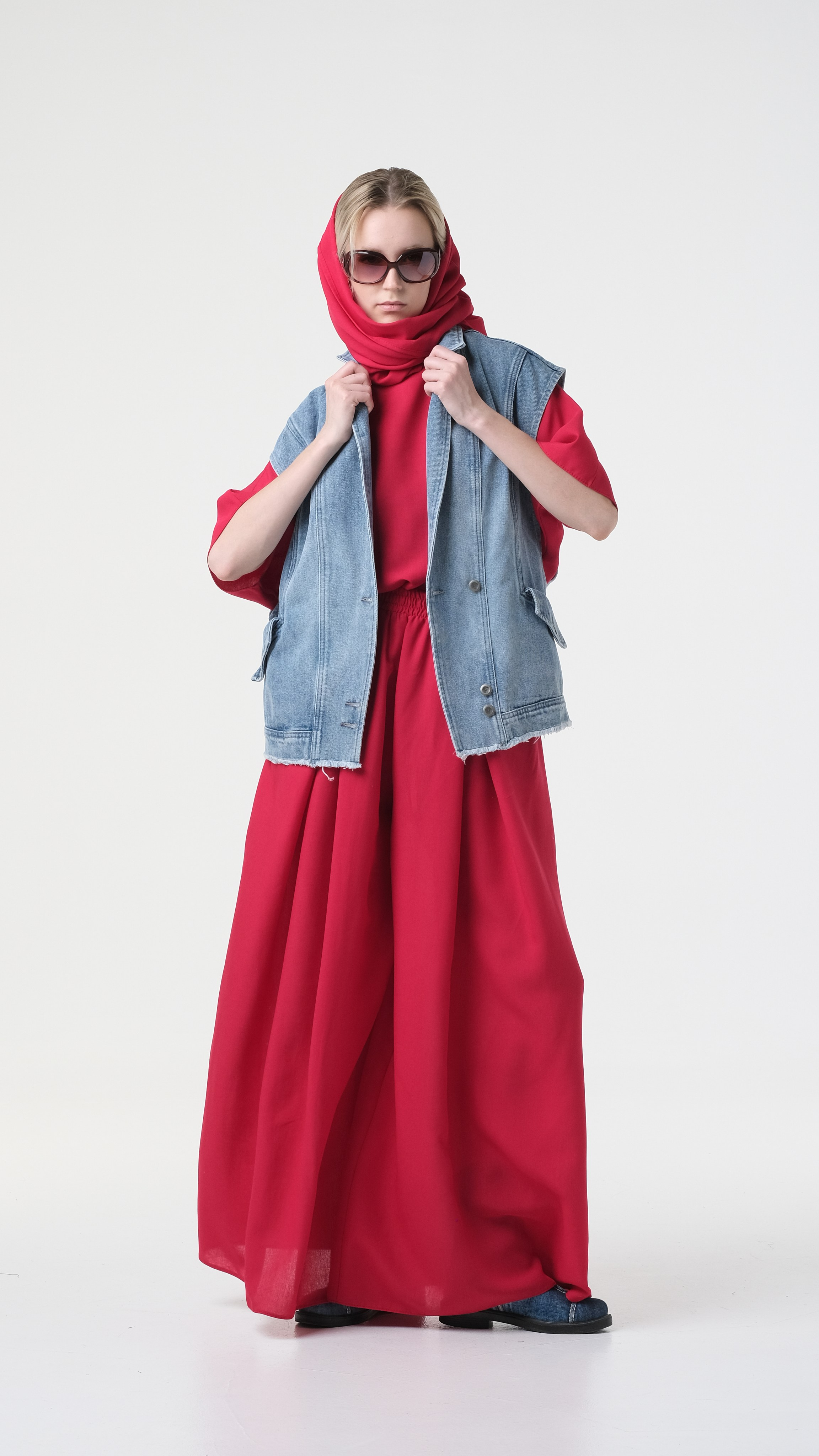 Сочетание красного костюма с джинсовой безрукавкой. Красивая девушка в красном платке, в очках, в красном платье и в джинсовой безрукавке.