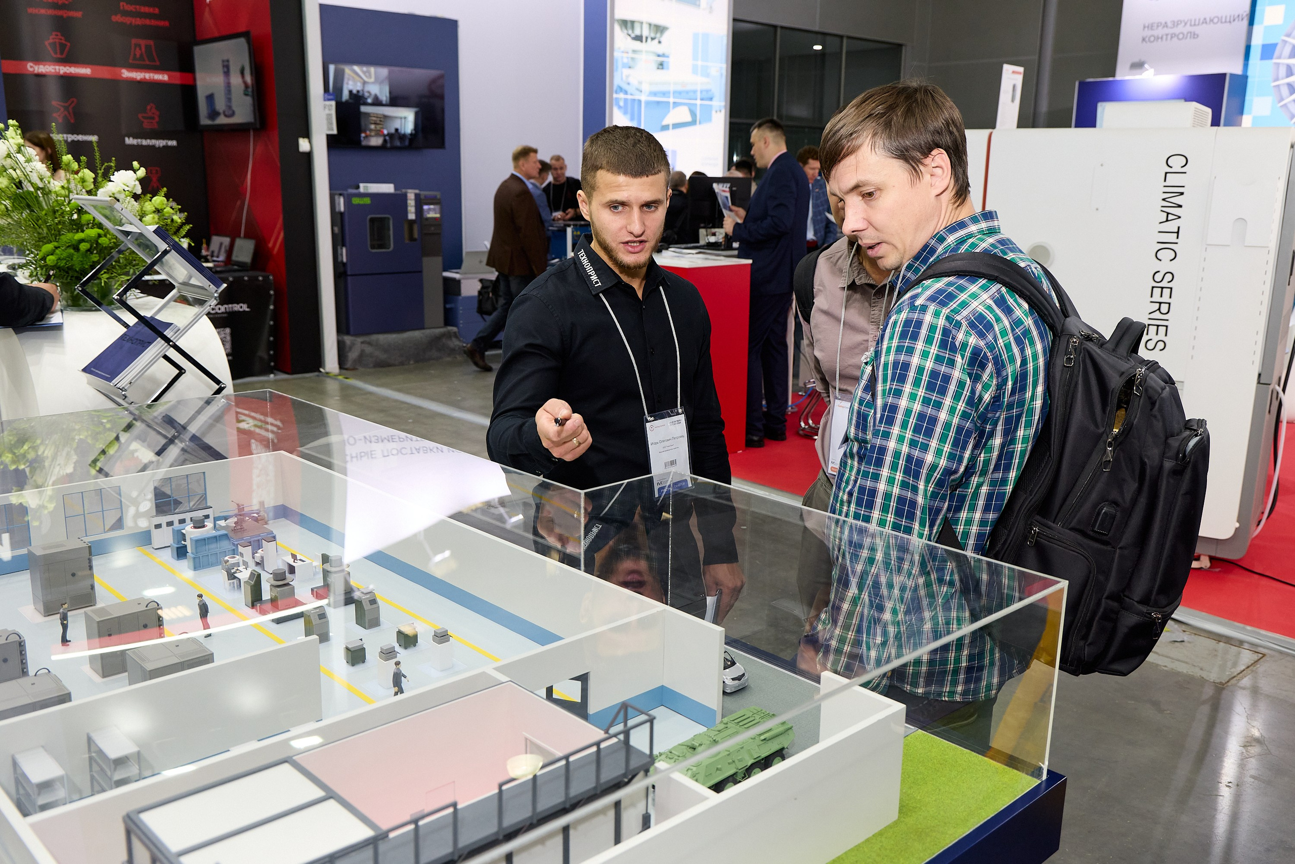 менеджер показывает макет на выставке 