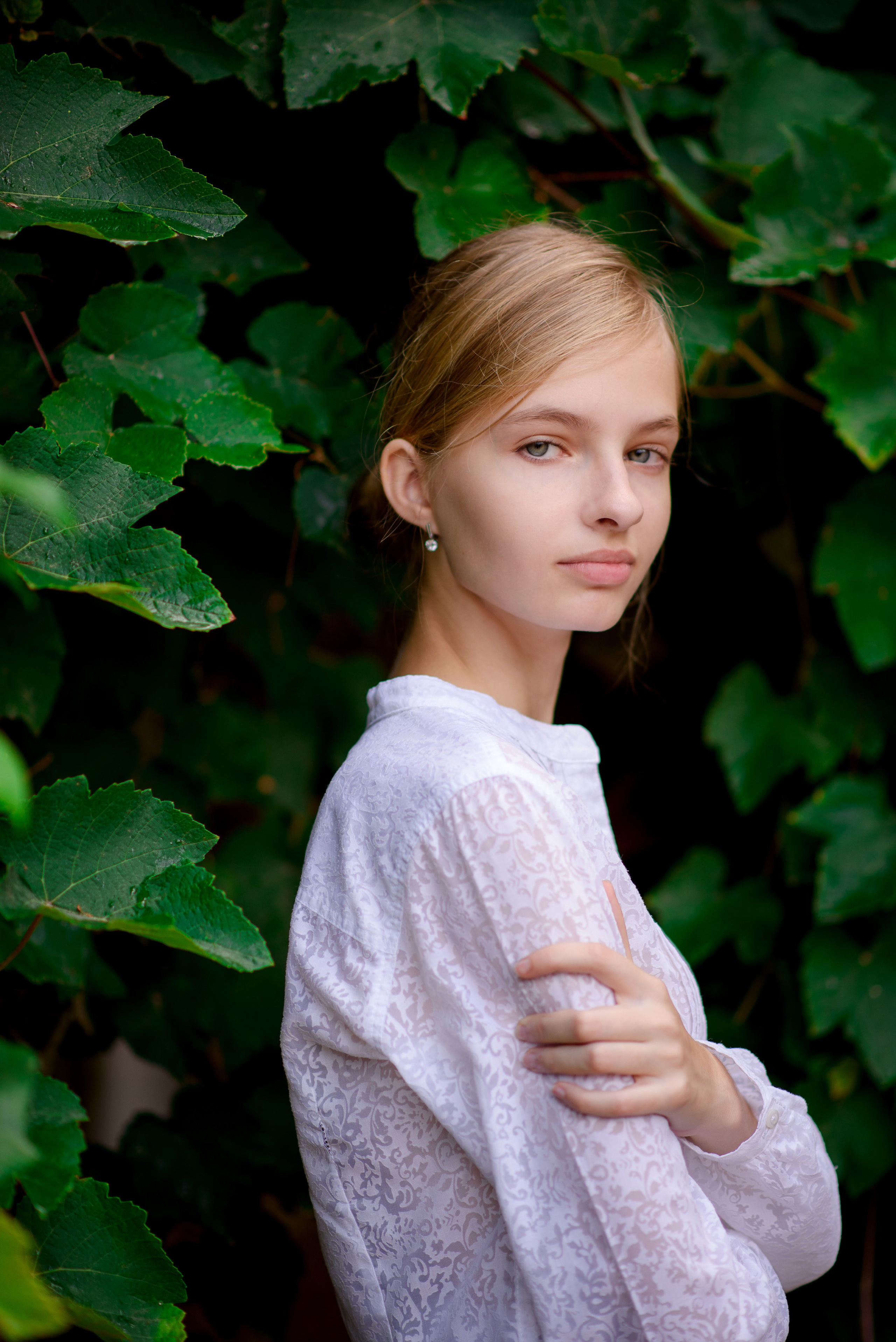 Портрет девочки на фоне зеленых листьев