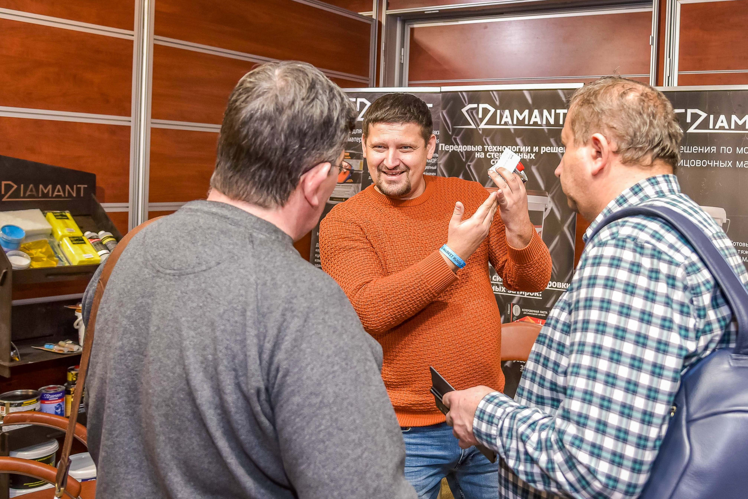 Репортажная съемка с выставки в Москве: снимок передаёт атмосферу общения между представителем компании и посетителями выставки.