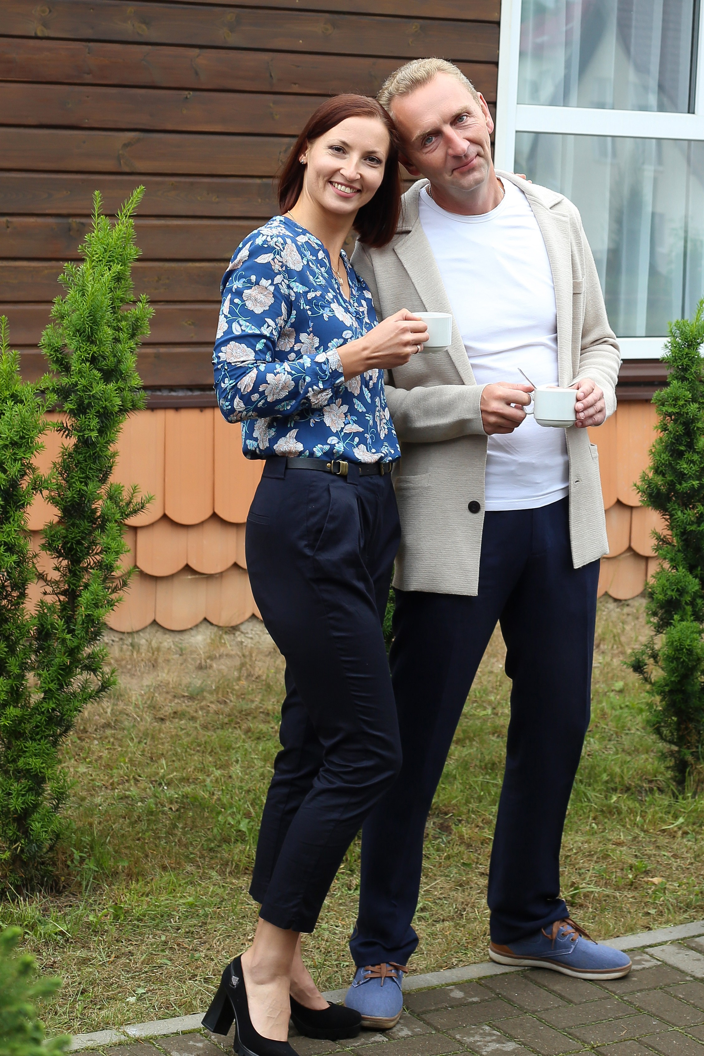 Молодая пара женщина и мужчина пьют кофе утром во дворе