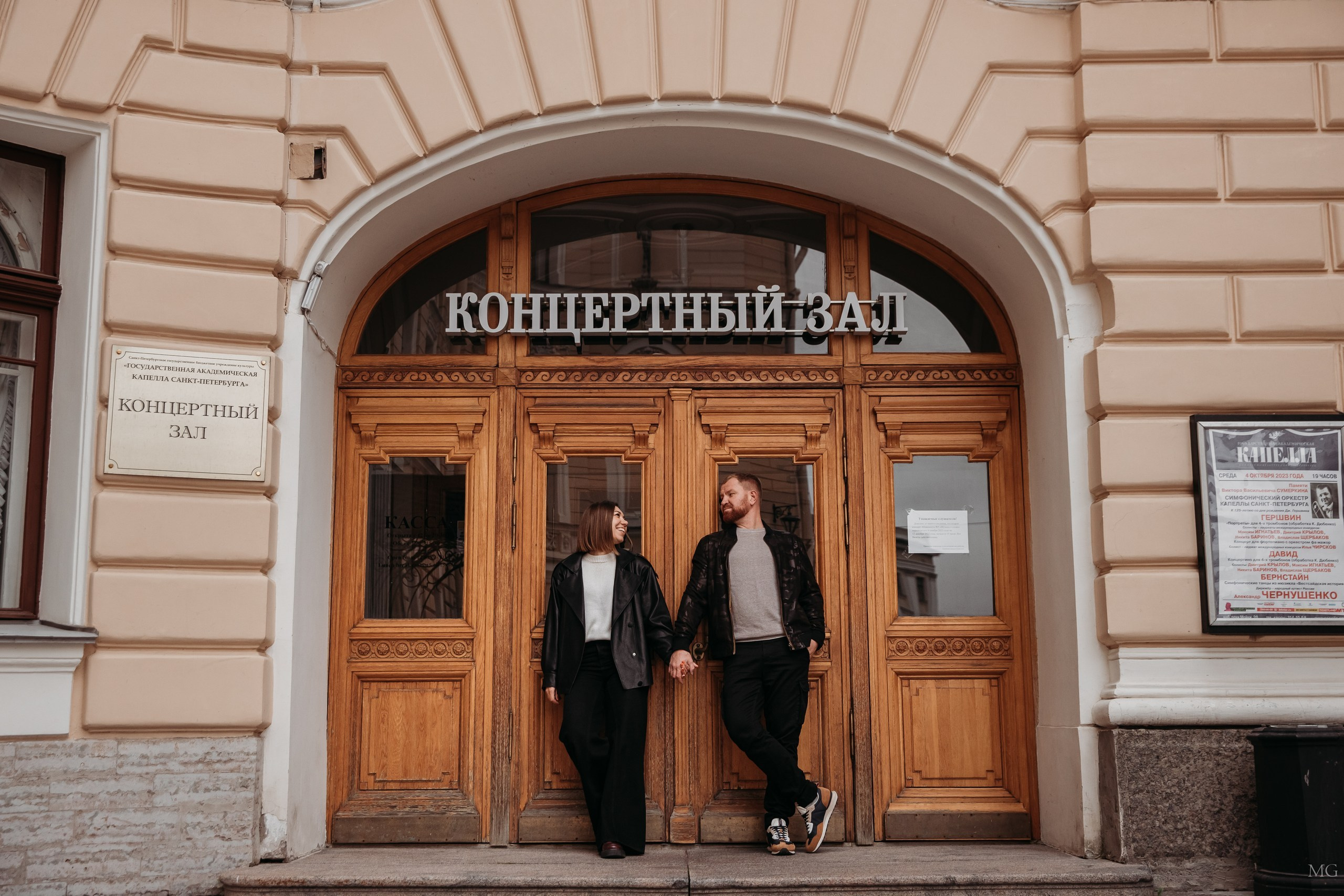 Влюбленные держатся за руки у концертного зала Капеллы в Петербурге