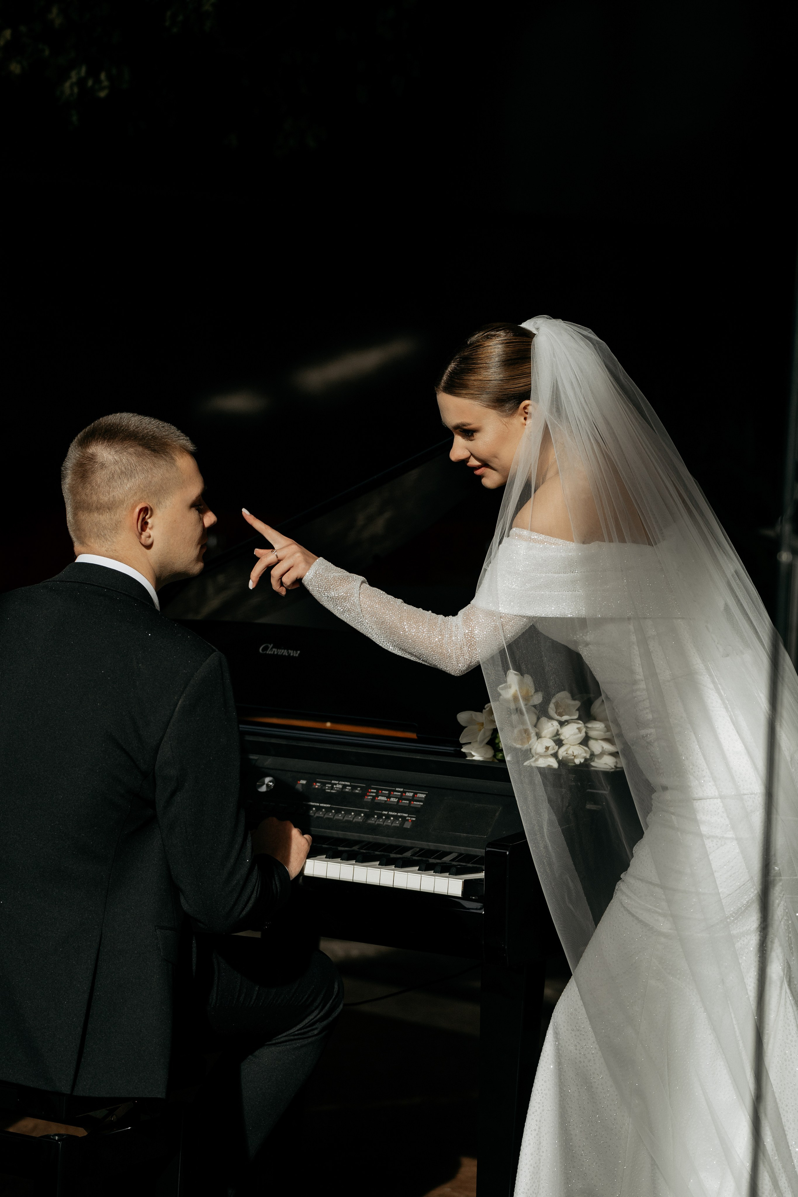 Свадебная фотография молодожен, жених играет на клавишном инструменте 