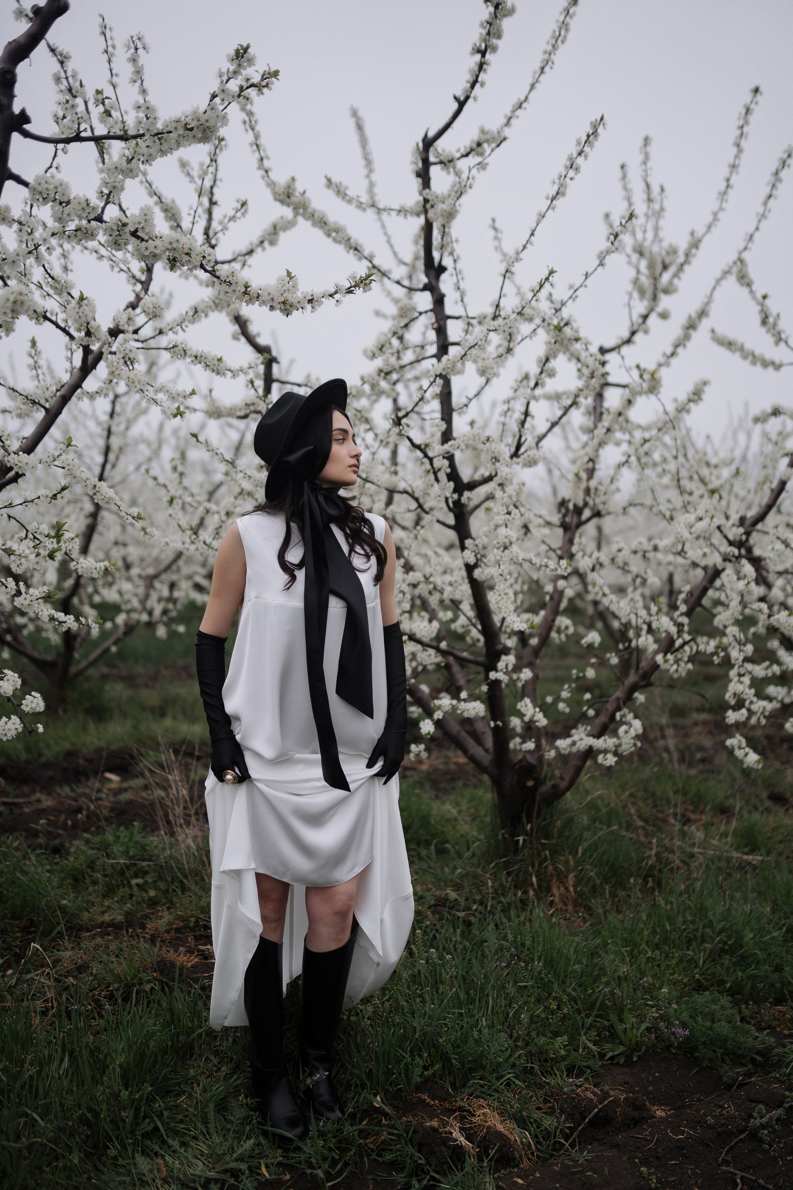 Девушка мечтательно смотрит вдаль среди цветов в Анапе  