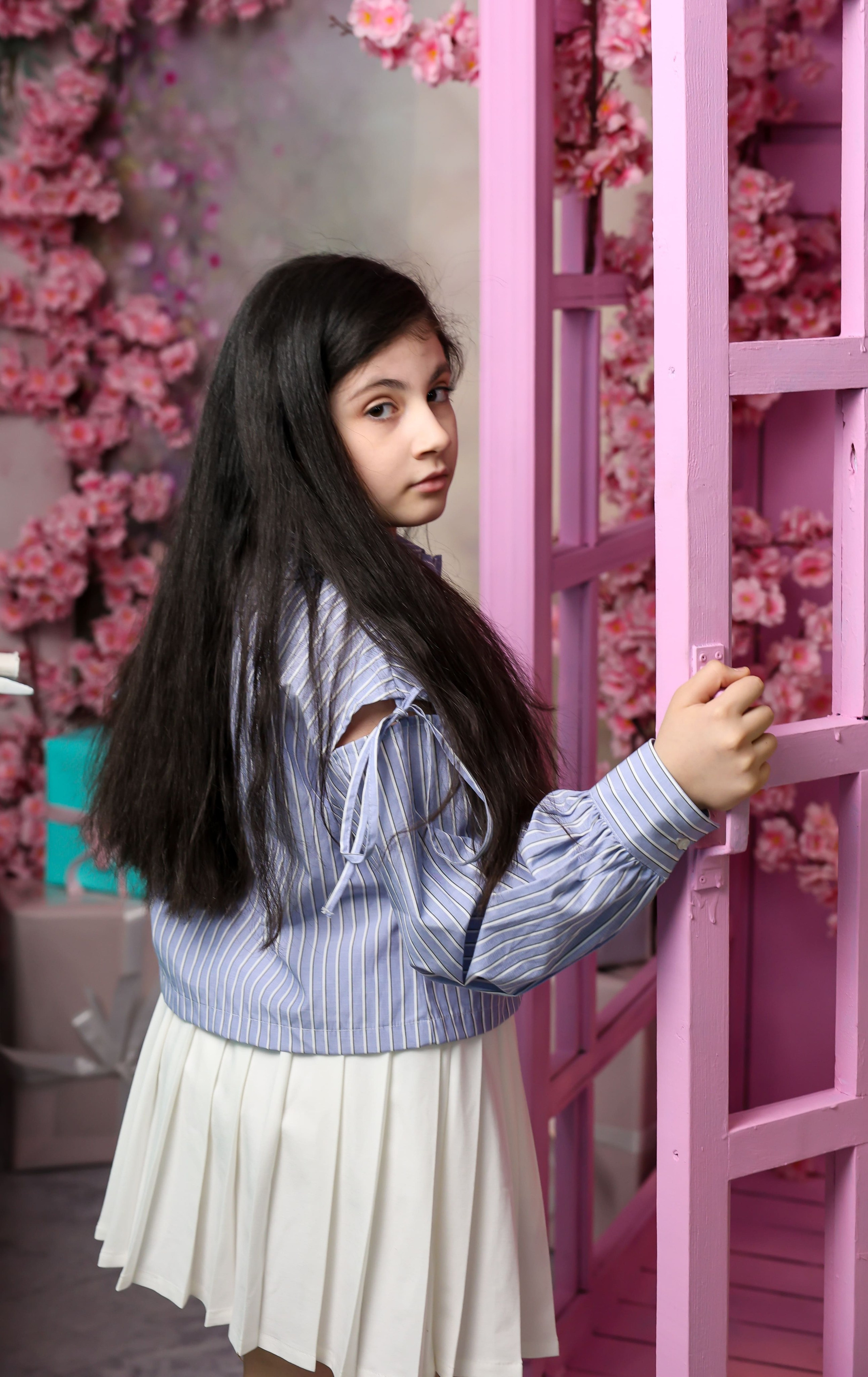 девочка у розовой двери с цветами, детская фотосессия в студии, фотограф Карасёва Елена