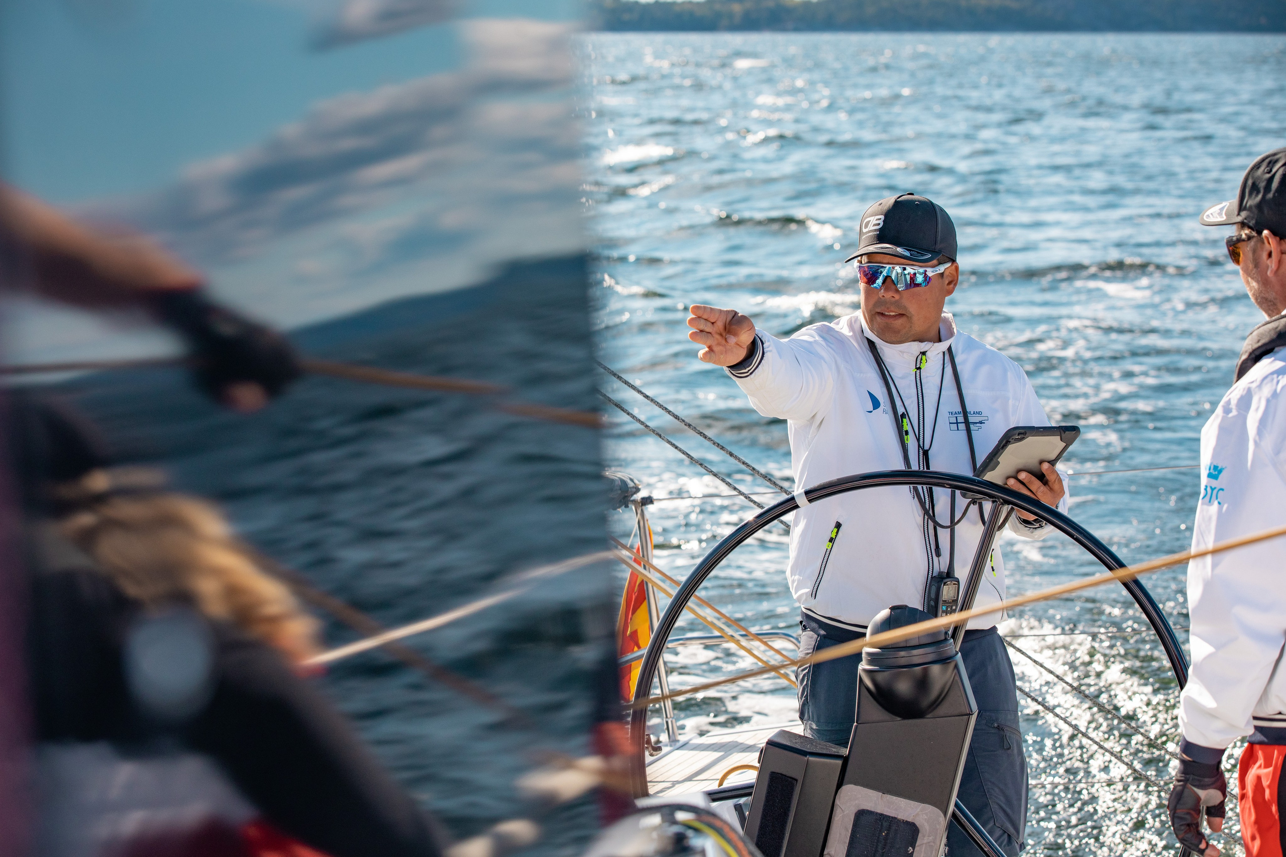 Навигатор на парусной яхте указывает путь, другой спортсмен отражается на иллюминаторе