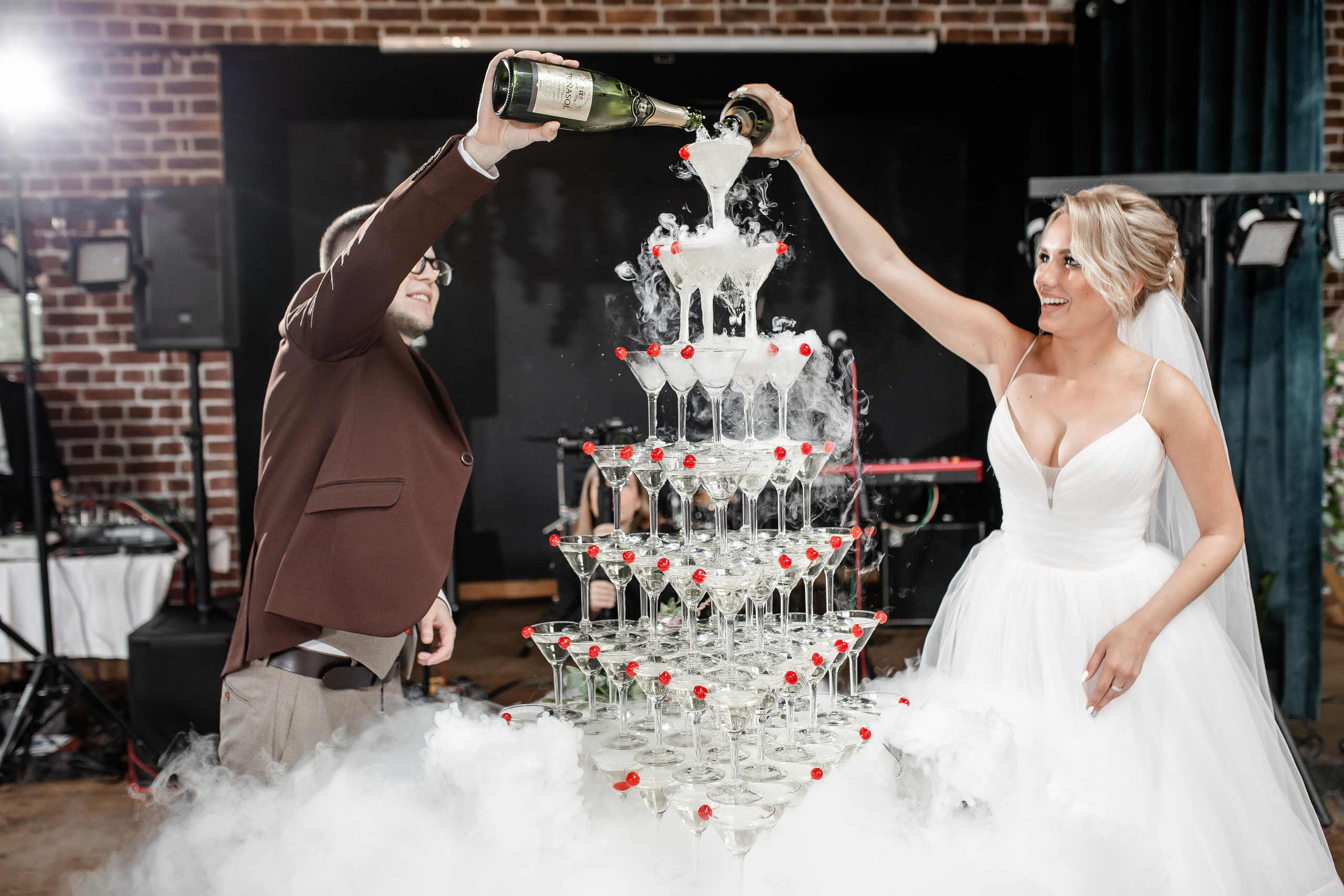 невеста с женихом наливают шампанское в пирамиду