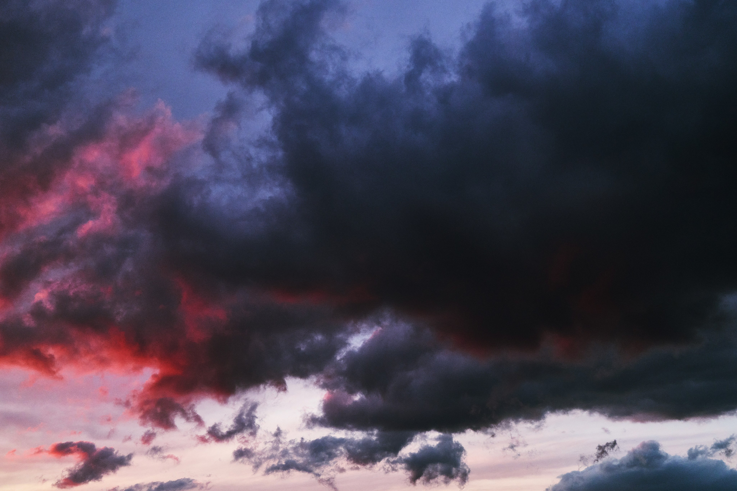 Горизонтальный фон (текстура) в высоком разрешении с атмосферным закатом с чёрно-синими тучами и розовато-красными облаками